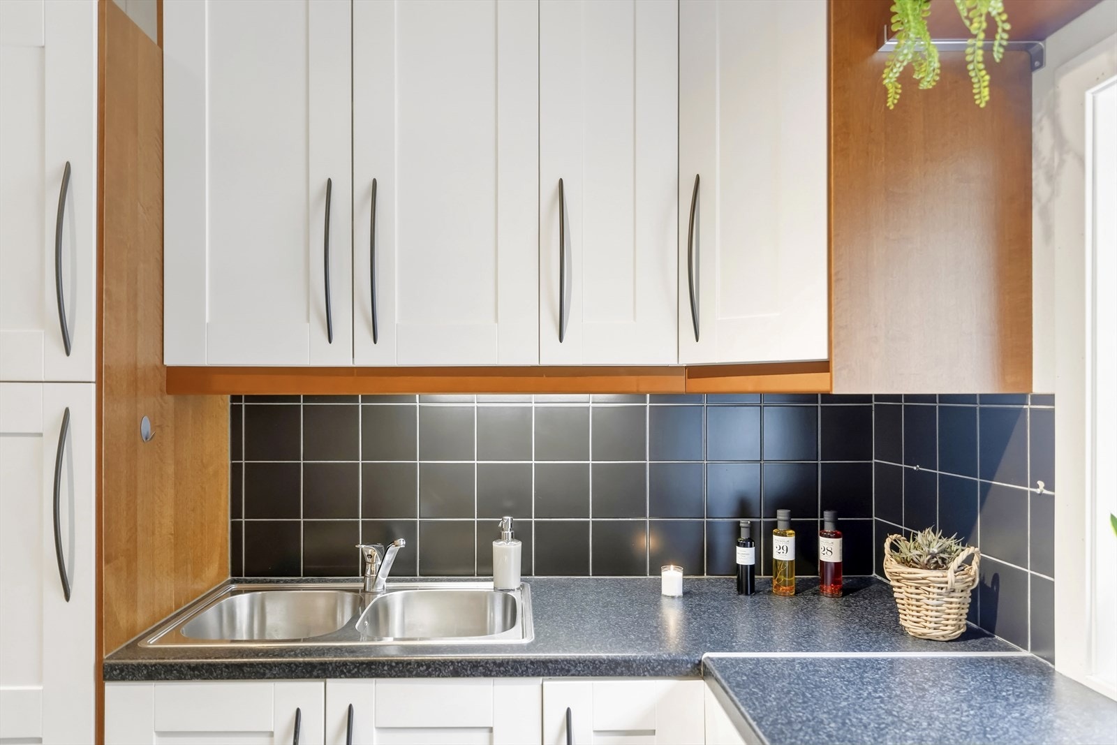 Kjøkkenet har et areal på 9,3 m² og fremstår med laminat på gulv, mdf panel på veggene og takplater i himlingen. Innredningen har profilerte fronter, og benkeplaten er laminert med nedfelt stålkum. Galleribilde