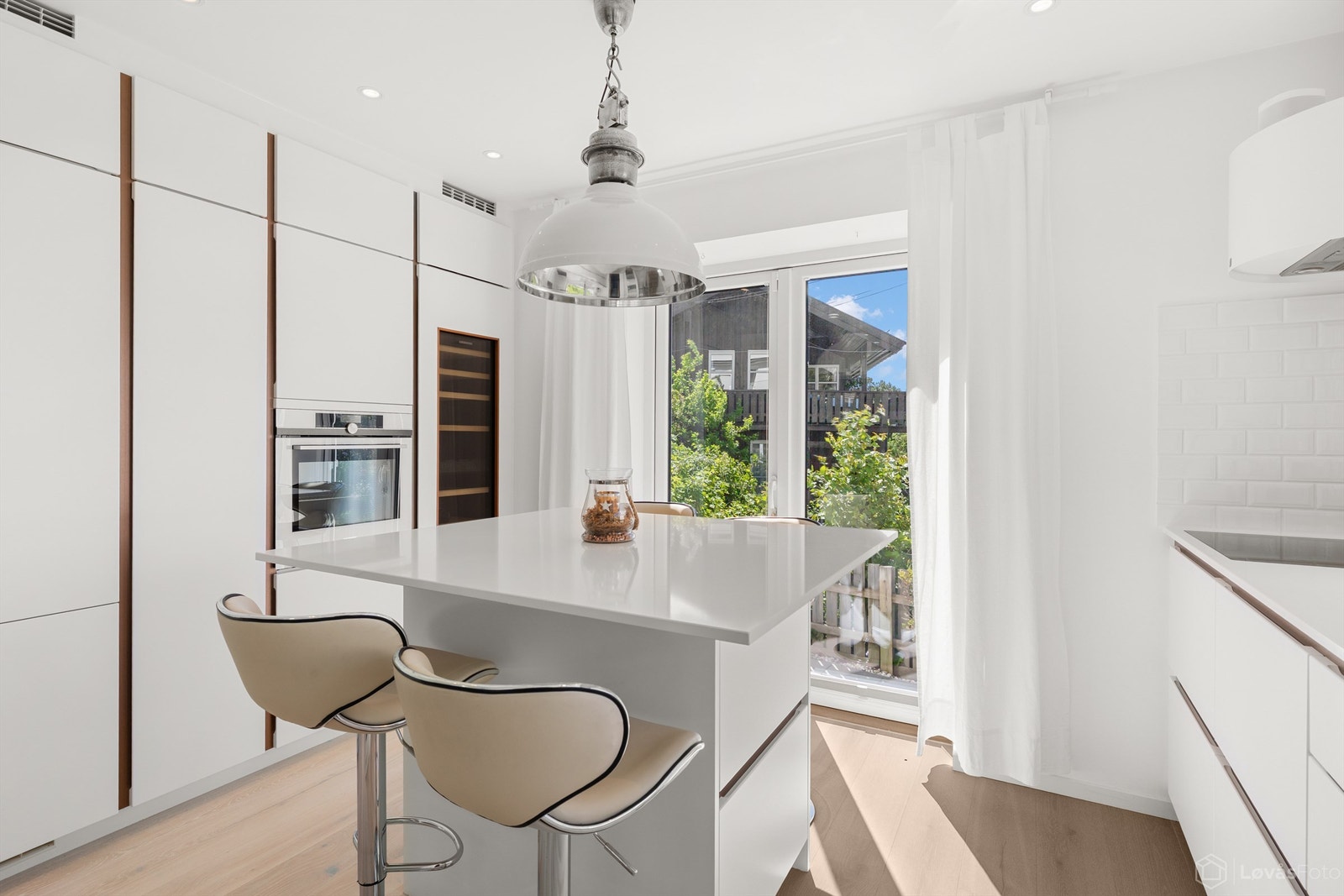 Lekker kjøkkeninnredning med en frittstående midtsentrert kjøkkenøy med plass til barstoler (barstolene følger boligen) Galleribilde