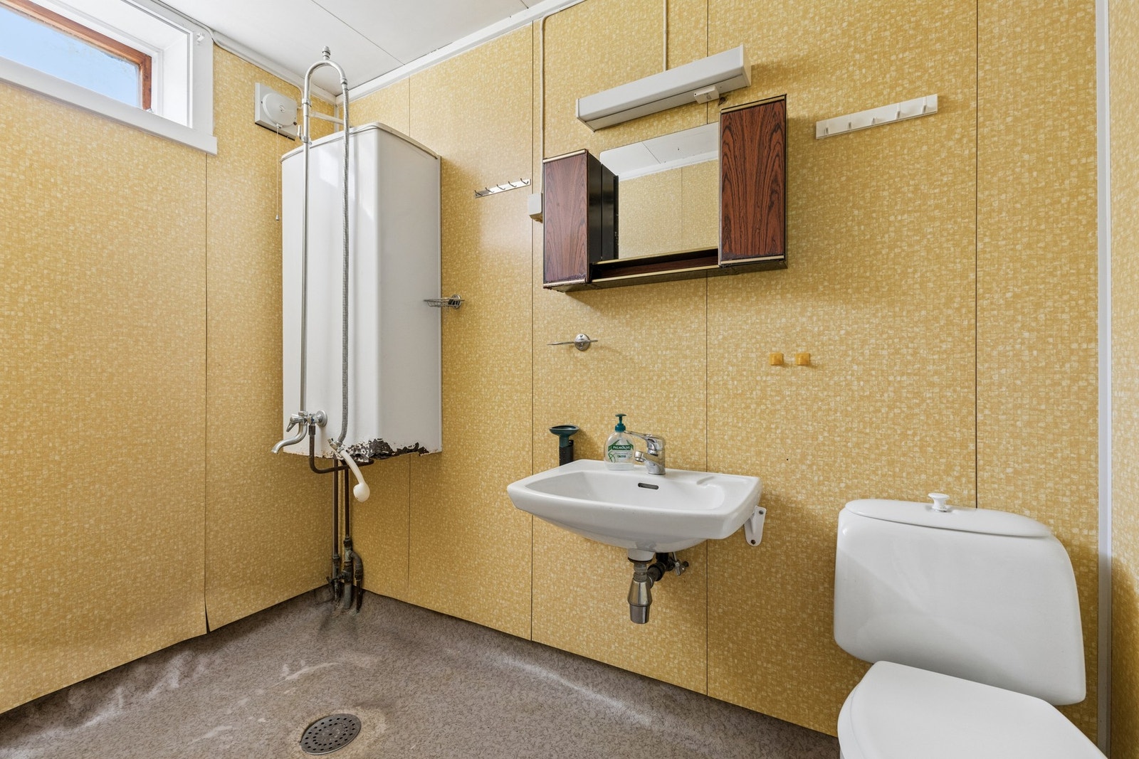 Badet i hybelen har baderomsplater på veggene, belegg på gulvet og avtrekksvifte. Galleribilde
