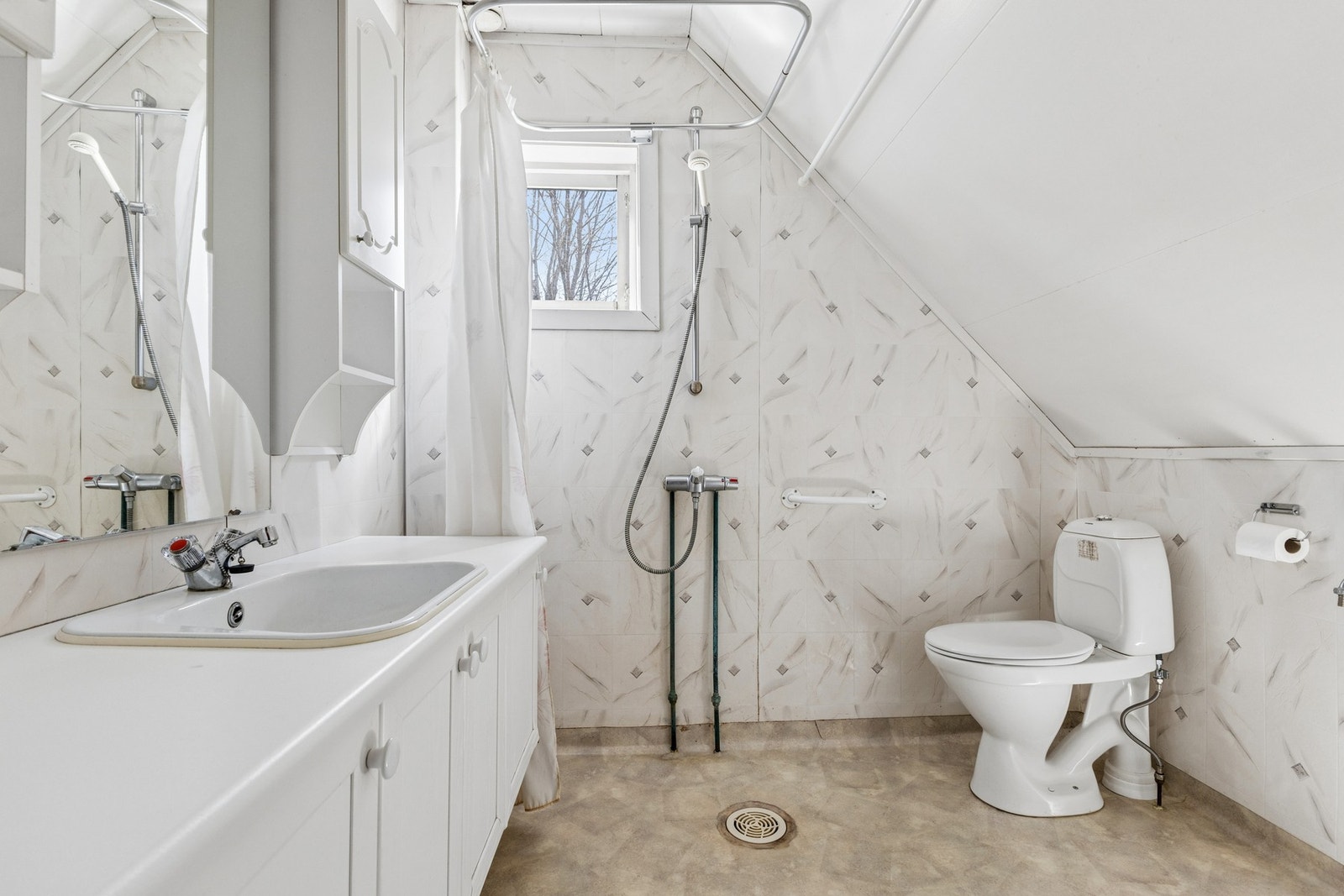 Badet på loftet er utstyrt med servantinnredning, toalett og dusjhjørne. Overflater med våtromstapet og vinylbelegg. Galleribilde