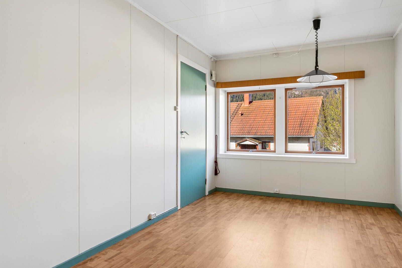Stuen i hybelen har laminat og belegg på gulv, og malte plater på veggene. Galleribilde