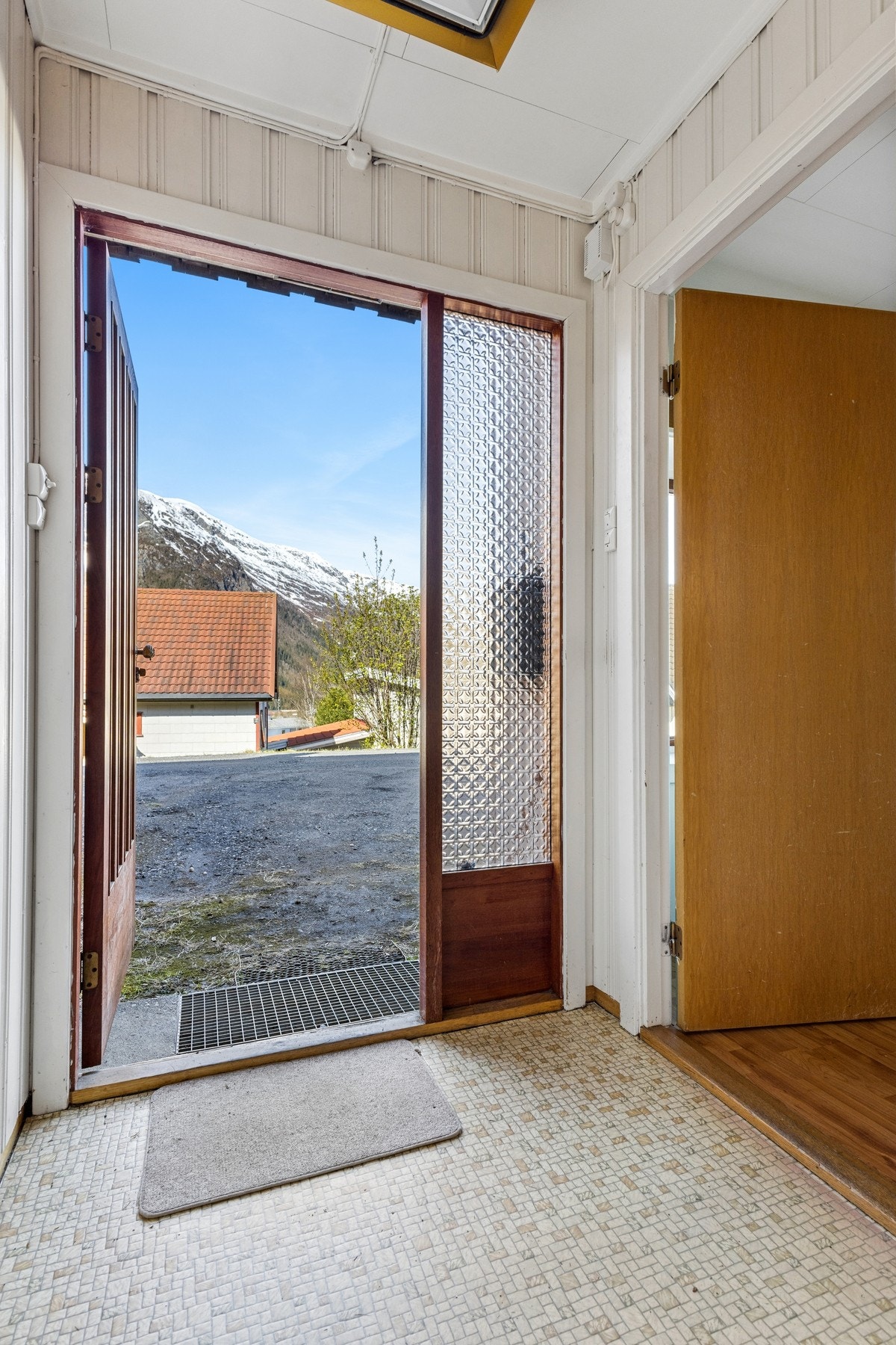 Ytterdøren er i teak med sidefelt i glass. Galleribilde