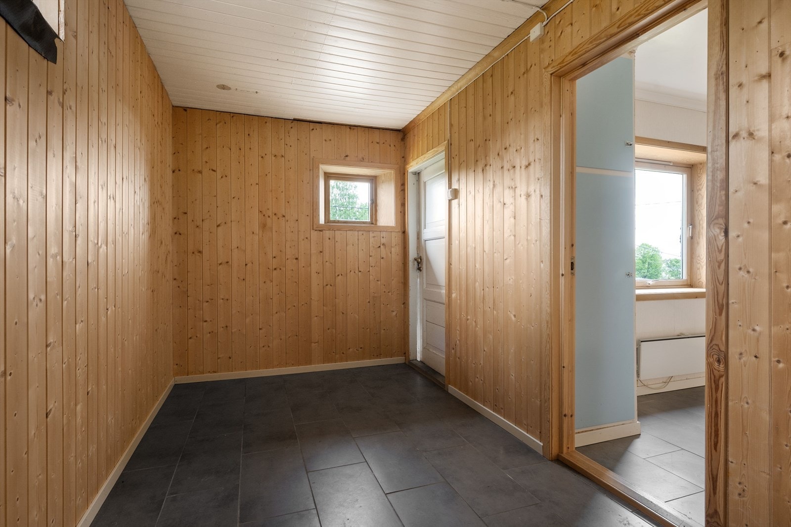 Gang i underetasje med fliser på gulv. Galleribilde