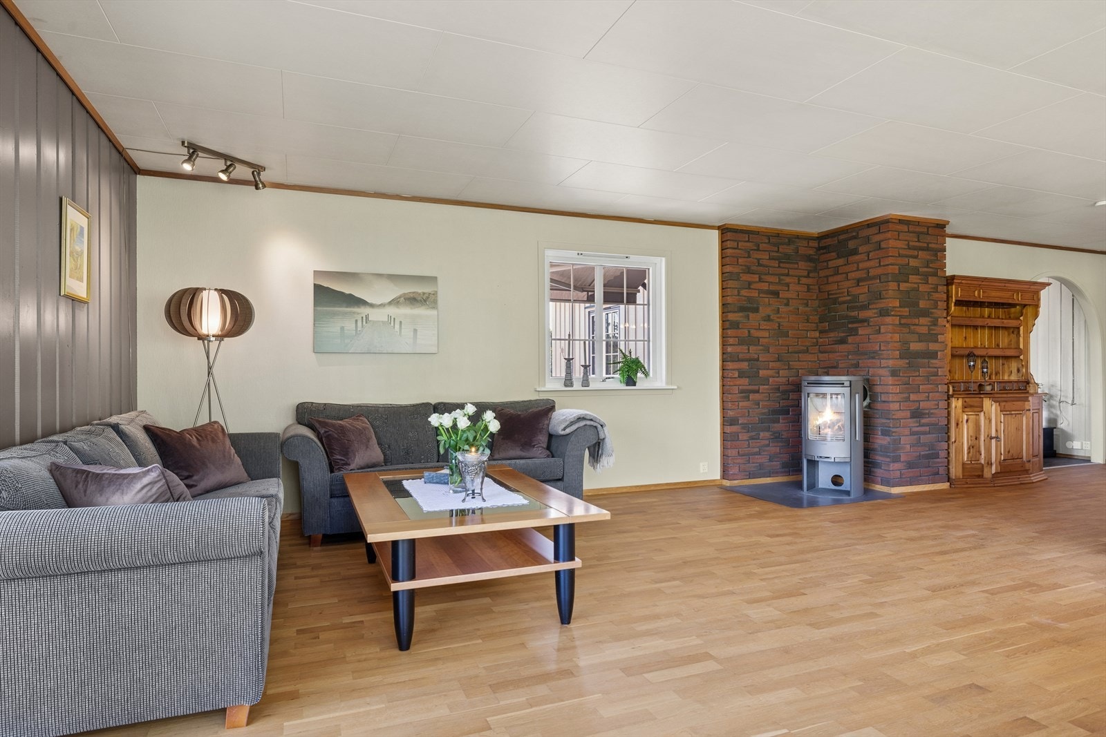 Stuen har vedovn som skaper en lun og innbydende atmosfære, kombinert med store vindusflater som gir mye naturlig lys. Den åpne romfølelsen legger til rette for en elegant og avslappende stue. Galleribilde