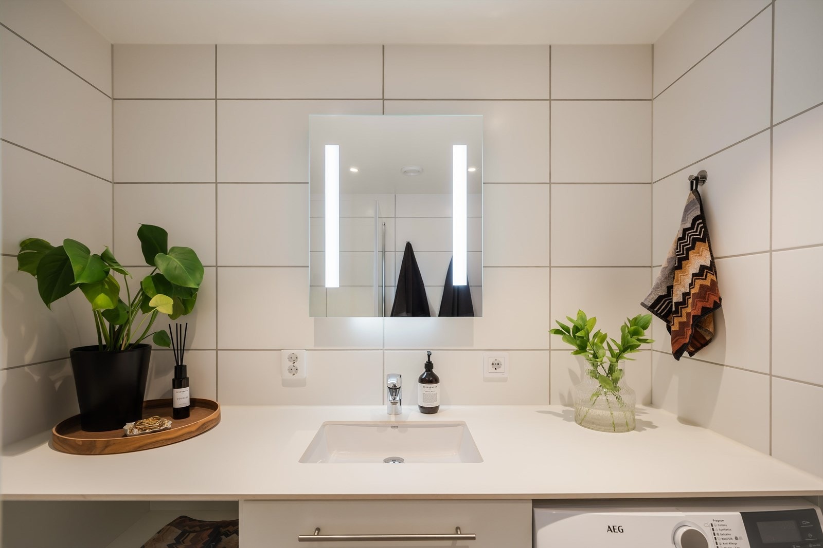 Videre har badet et vegghengt toalett, mekanisk avtrekk, opplegg for vaskemaskin og et dusjhjørne med innfellbare glassdører. Badet har fått tilstandsgrad 1, i følge takstmann. Galleribilde