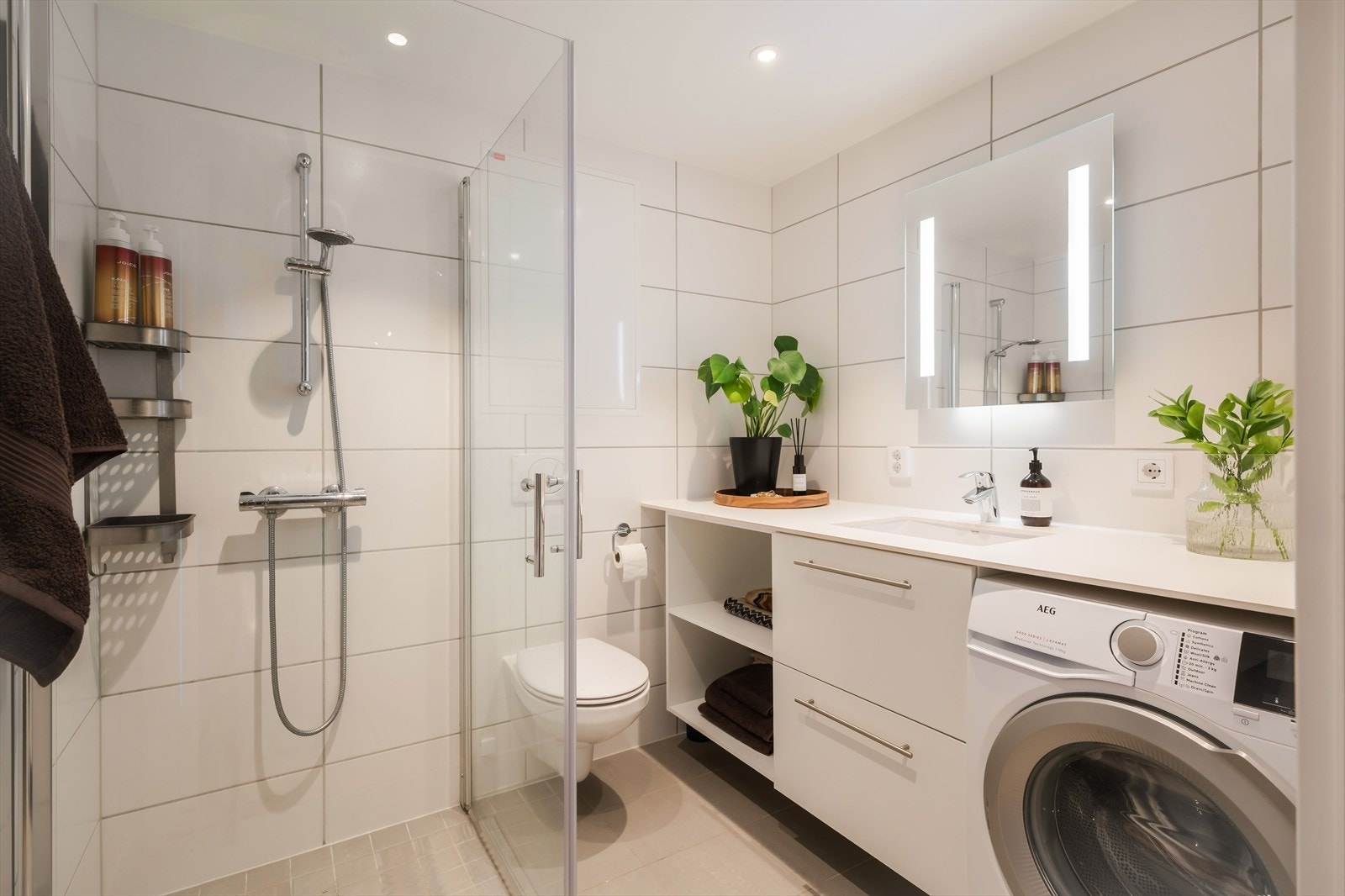 Badet, som er på ca. 4 kvm, fremstår som velholdt og pent, og har direkte adkomst fra entreen. Veggene på badet er kledd med lyse fliser, og det er downlights i himlingen og grå fliser på gulvet. Galleribilde