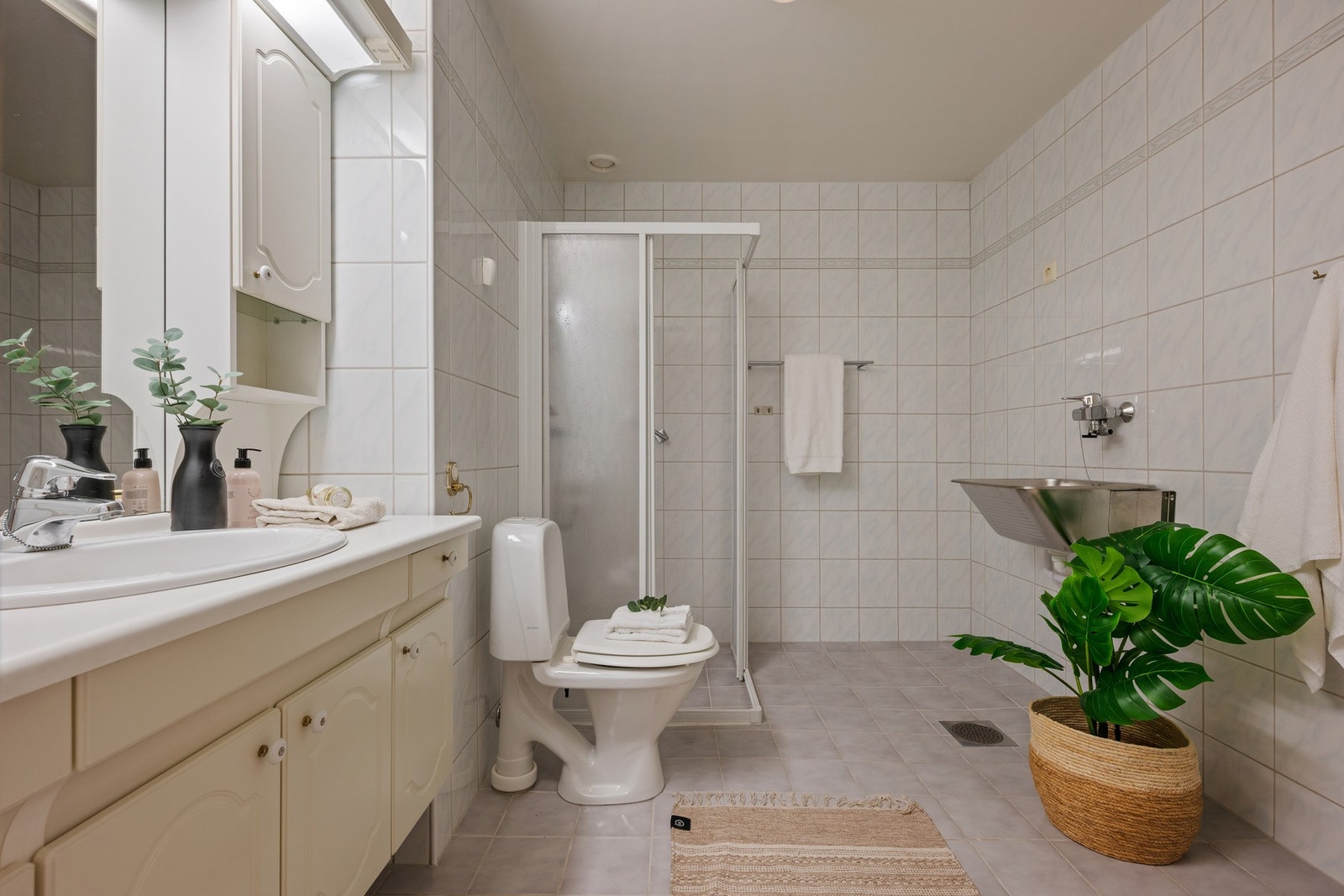 Flislagt baderom med varmekabler og opplegg for vaskemaskin. Galleribilde