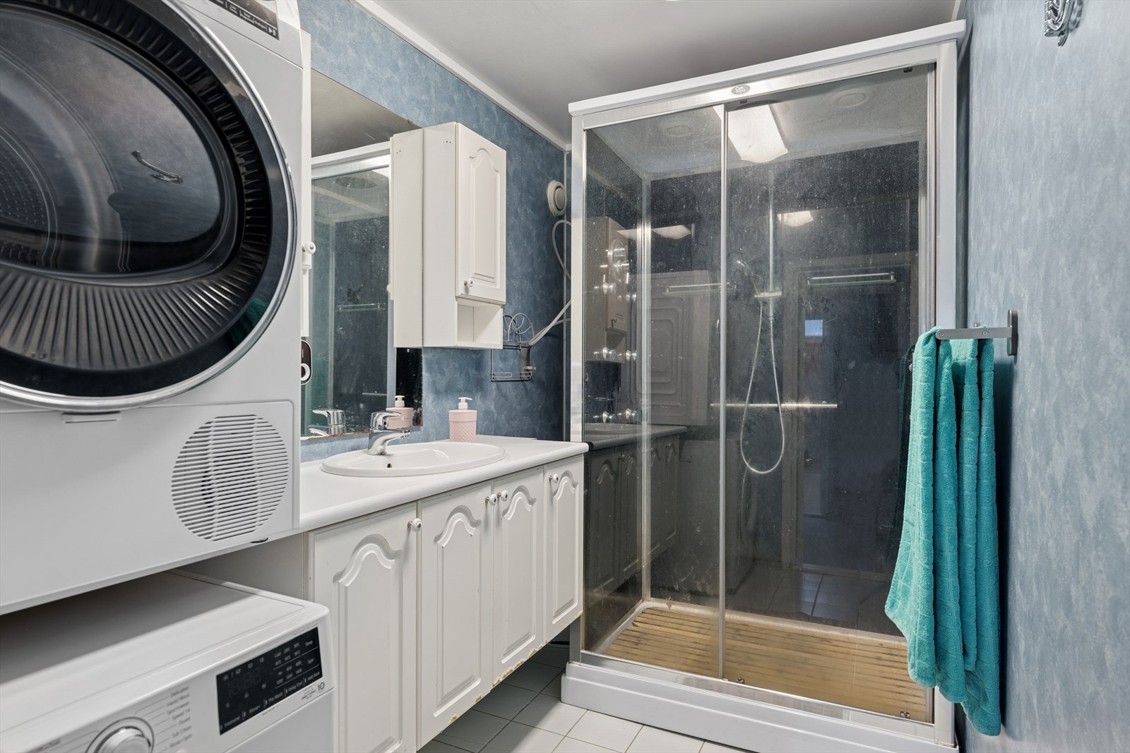 Badet er innredet med dusjkabinett, servant og har opplegg for vaskemaskin Galleribilde