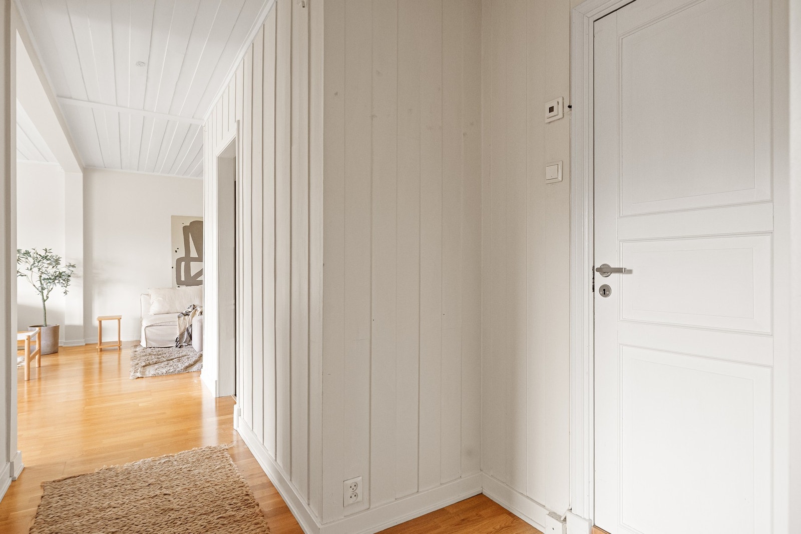 Entréen gir et lyst førsteinntrykk av boligen, med lyse overflater og parkettgulv fra 2017 som skaper en helhetlig og tidløs ramme. Galleribilde