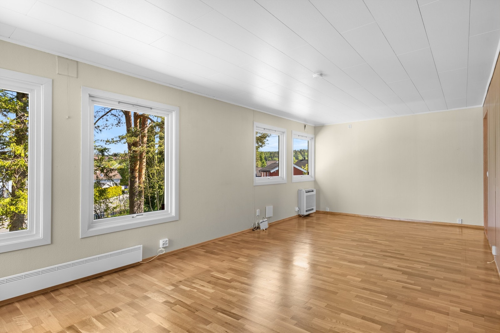 Parkett er lagt på gulvet, og utformingen gjør stuen enkel å møblere med flere sittegrupper Galleribilde