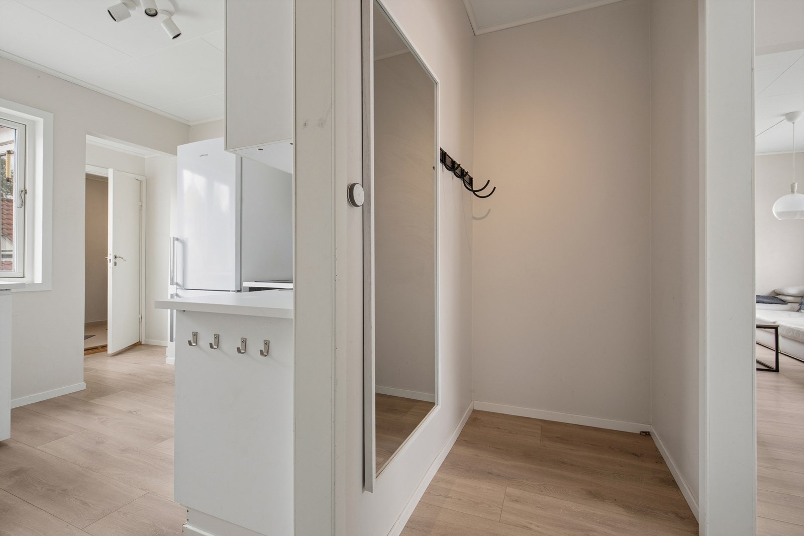 Man ønskes velkommen inn i en entré hvor man har god plass til å henge fra seg yttertøy og sko. Galleribilde