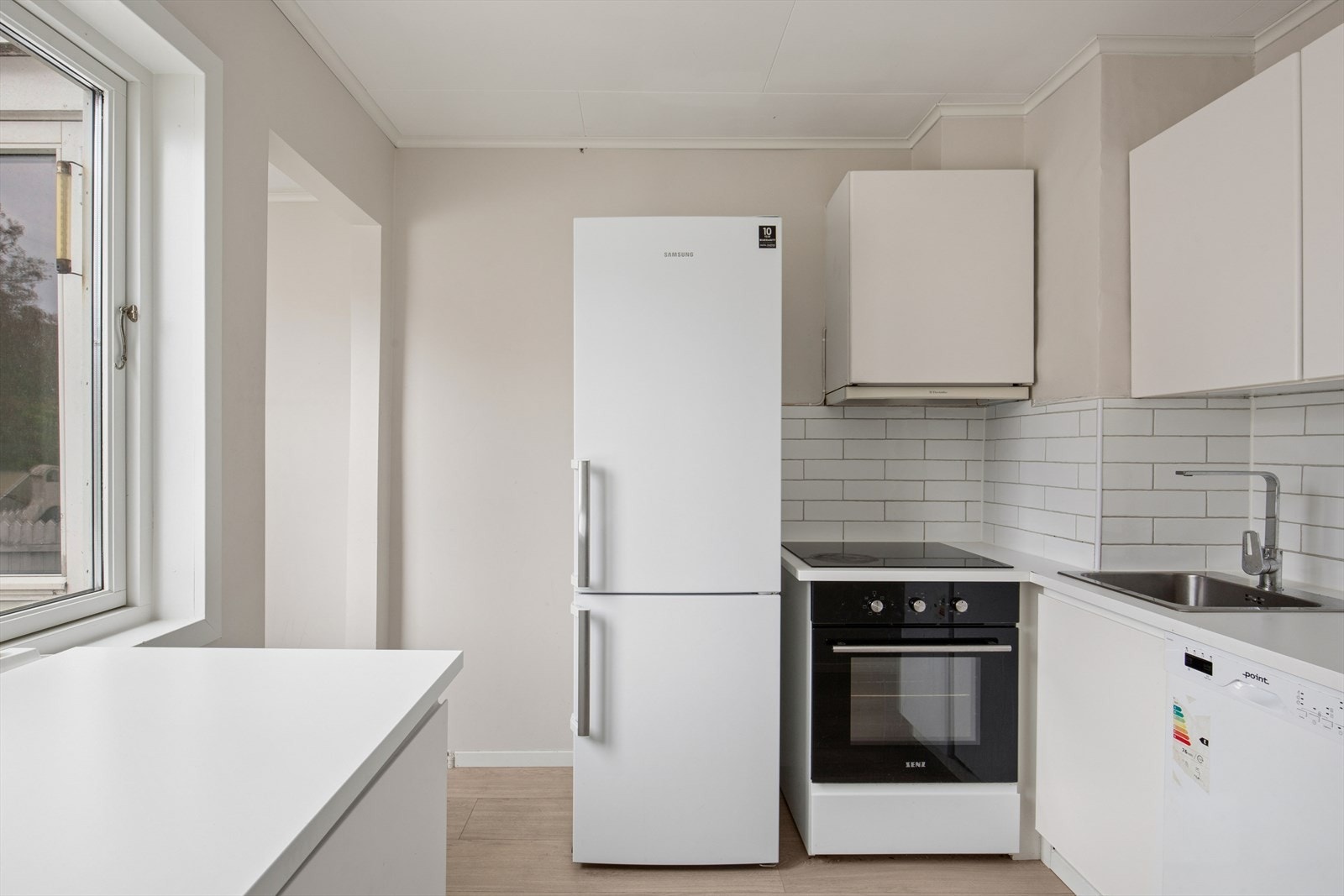 Kjøkkenet er ellers utstyrt med frittstående hvitevarer og kjøkkenventilator med avtrekk ut. Galleribilde