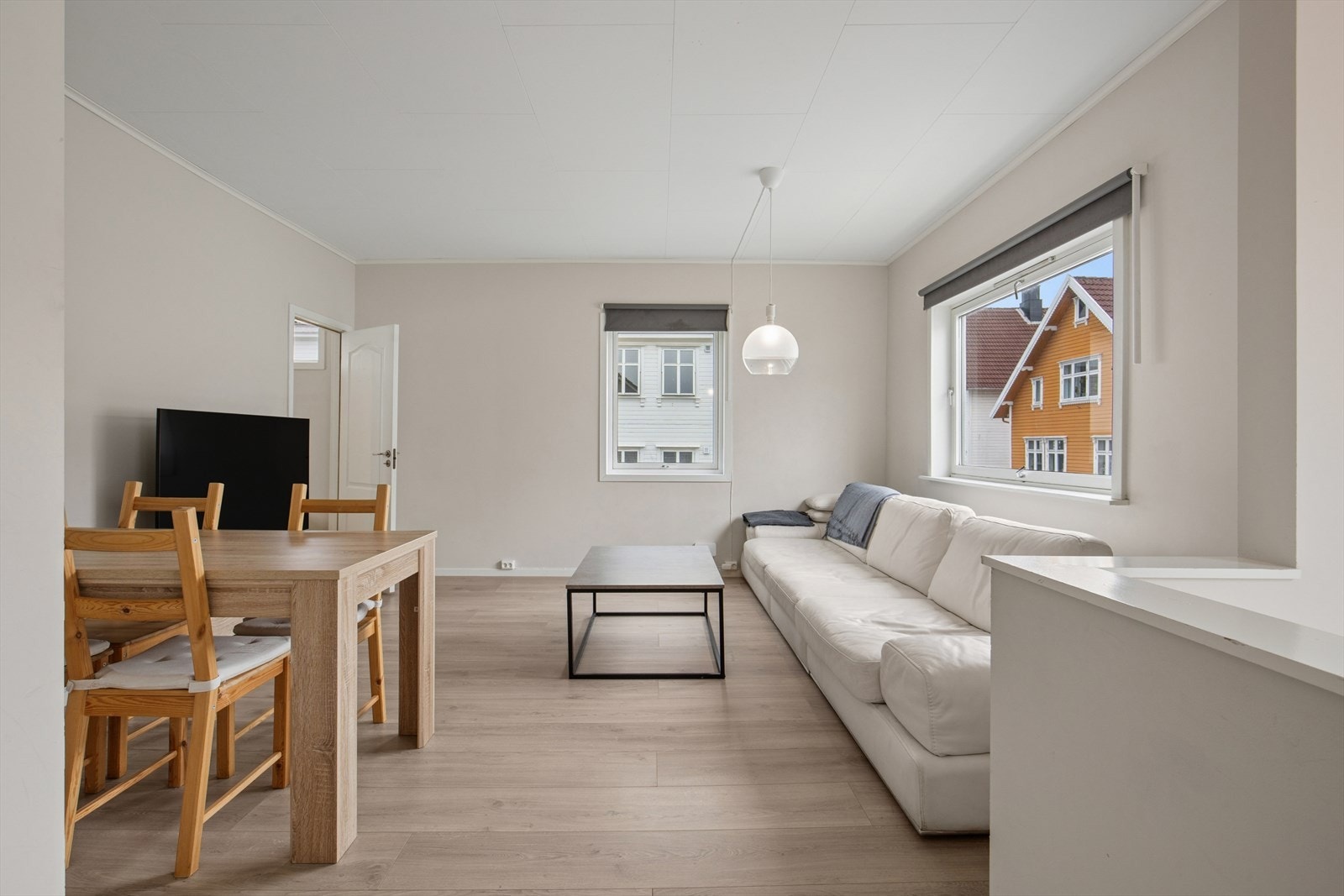 Stuen er romslig og har store vindusflater som gir rikelig med naturlig lys. Her har man god plass til å møblere i flere soner med både sofa og spisegruppe. Galleribilde