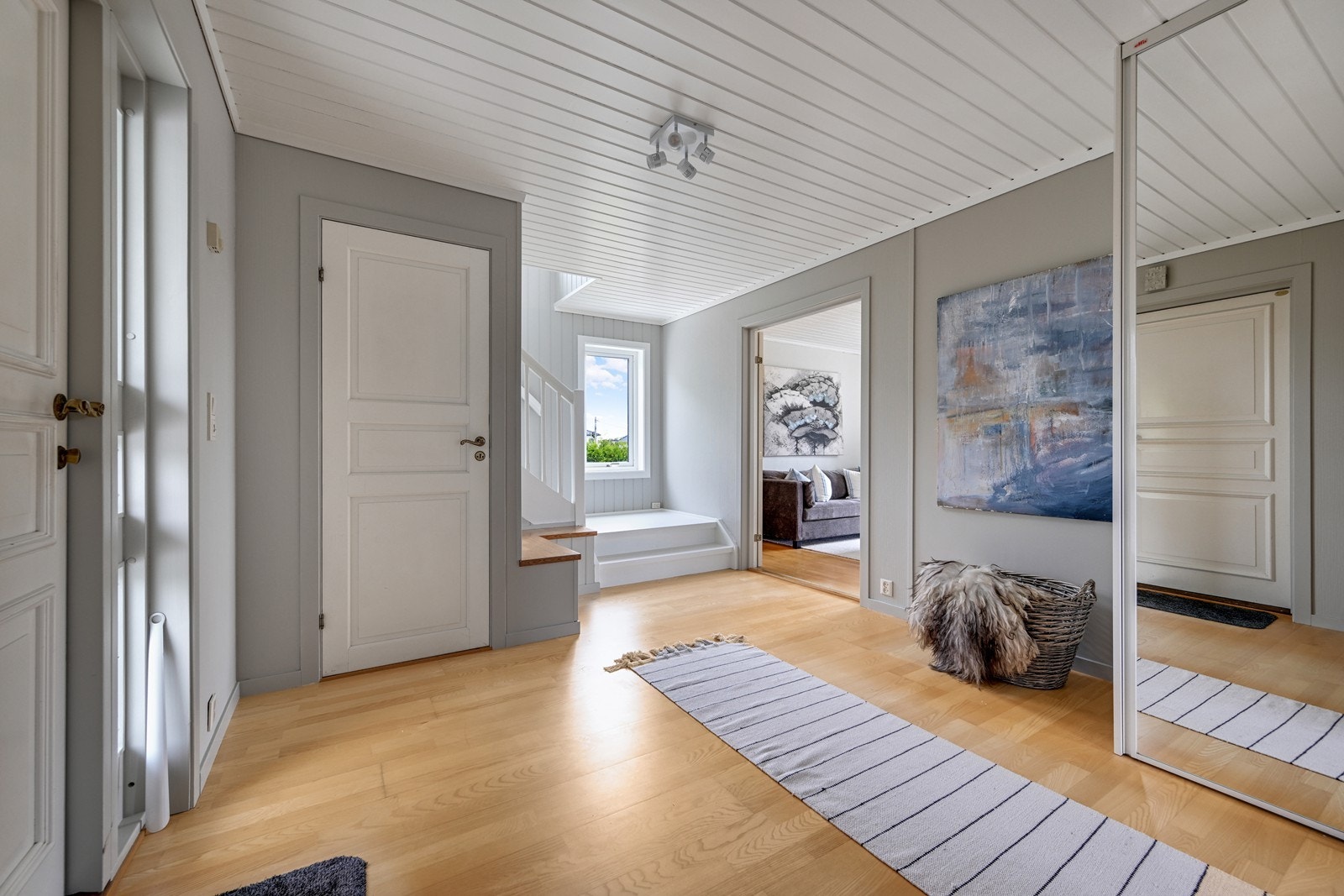 Romslig hall med skyvedørs garderobe og trapp til 2. etasje og til kjeller. Galleribilde