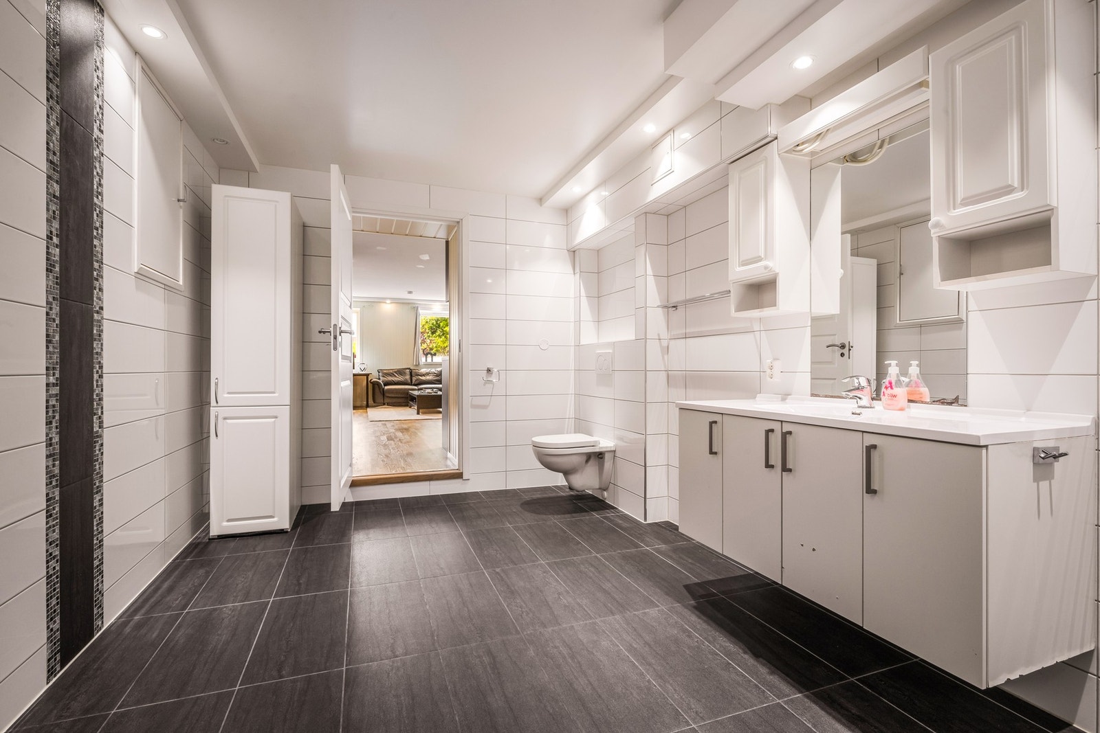 Innfelte downlights i tak og varmekabler i gulv bidrar til god komfort. Badet er innredet med dusj, vegghengt toalett, baderomsinnredning, varmtvannstank og opplegg for vaskemaskin. Galleribilde