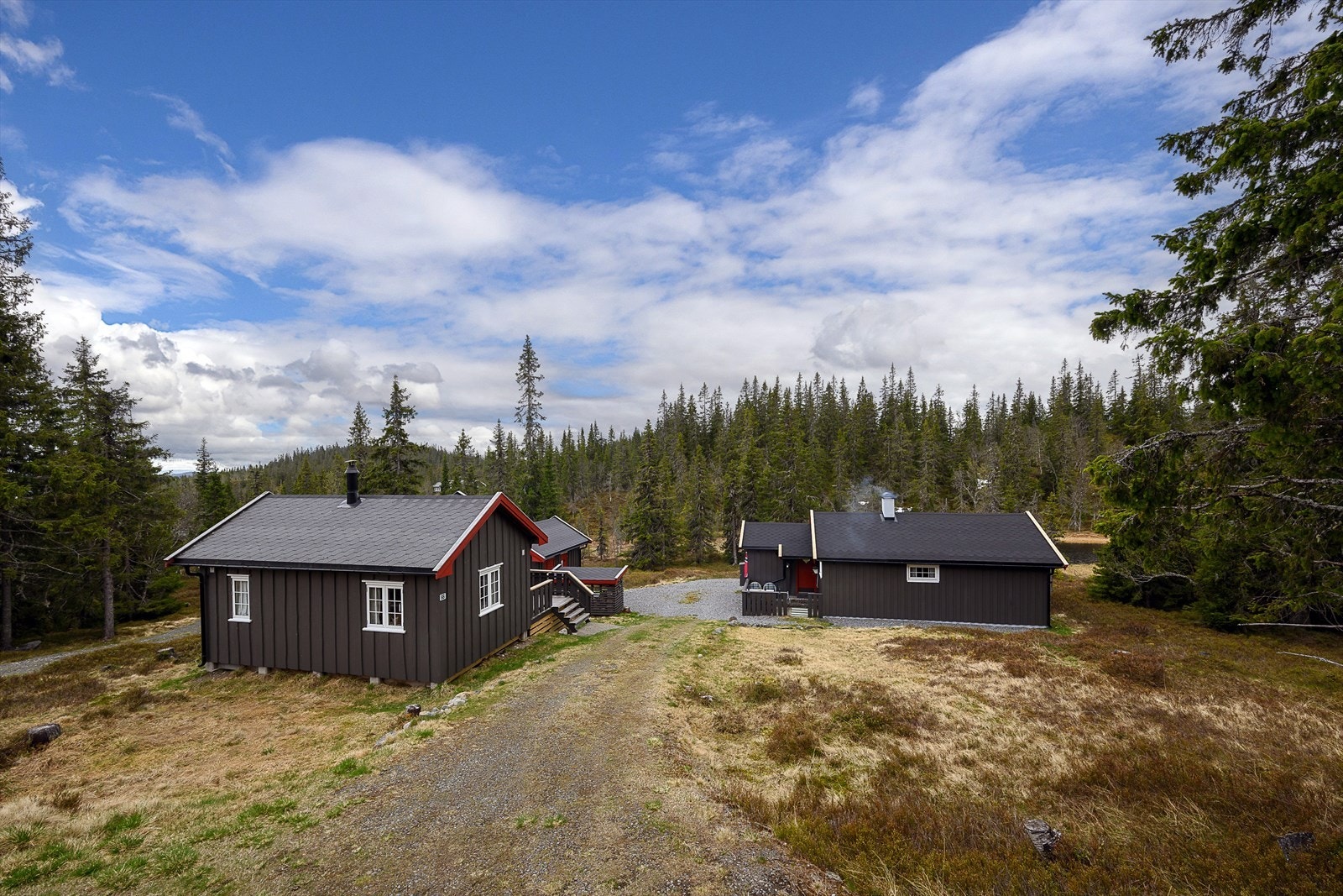 Oversikt over hyttetunet, som ligger fritt og åpent i terrenget. Galleribilde