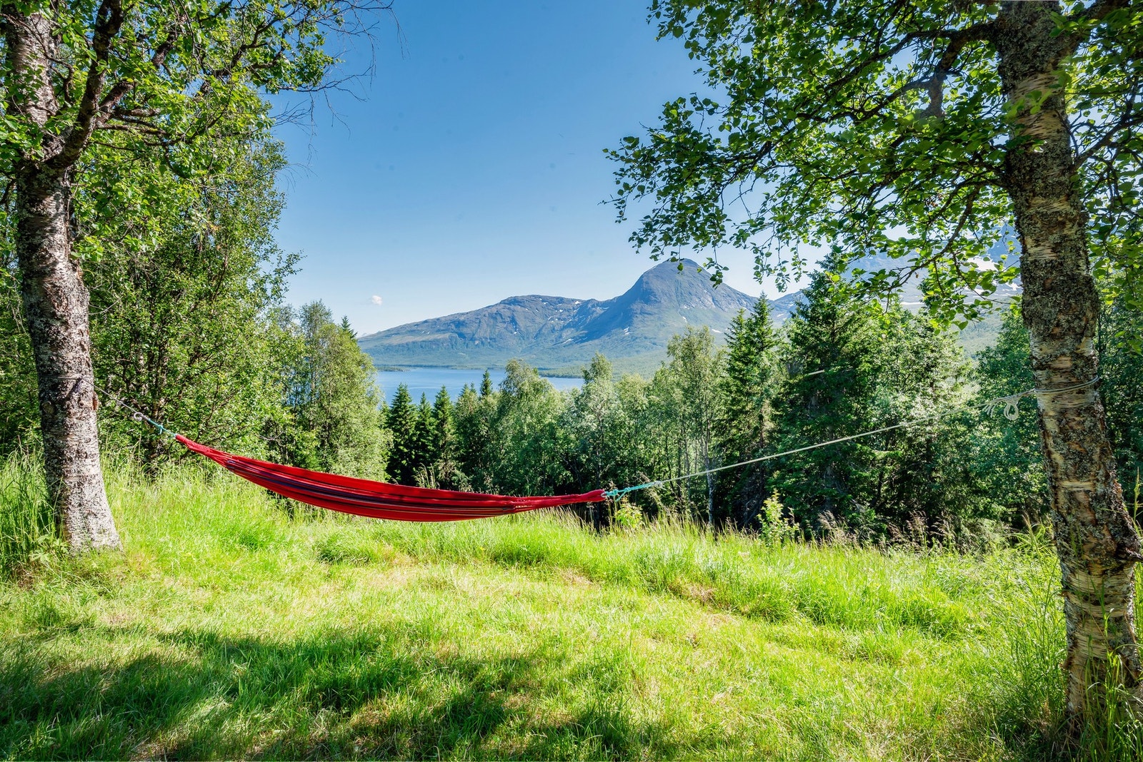 Hyttetunet ligger lunt og usjenert til, med flott utsikt over innsjøen og omkringende fjell Galleribilde