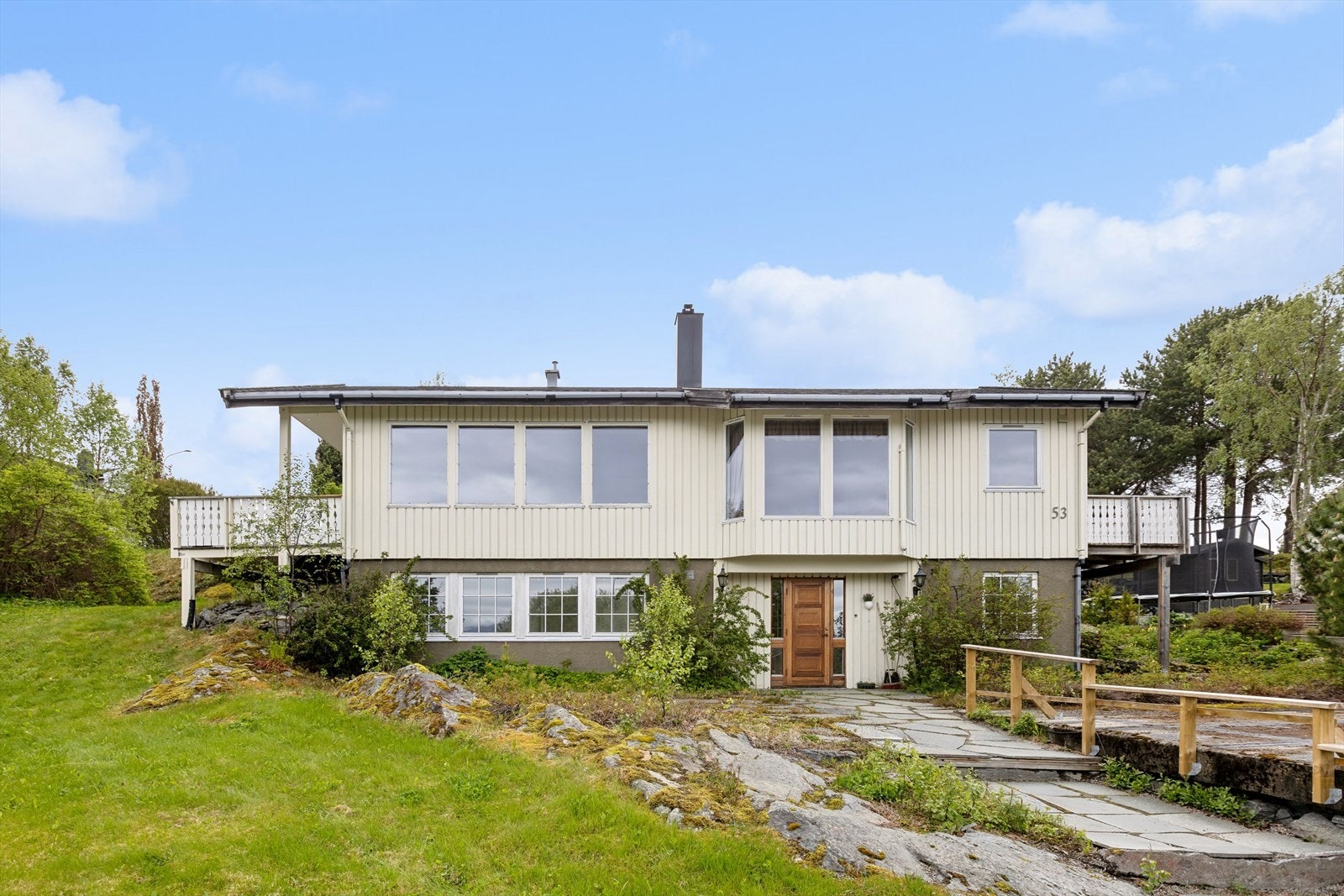 Boligens fasade har stående trekledning og liggende kledning i gavlfeltet. Galleribilde