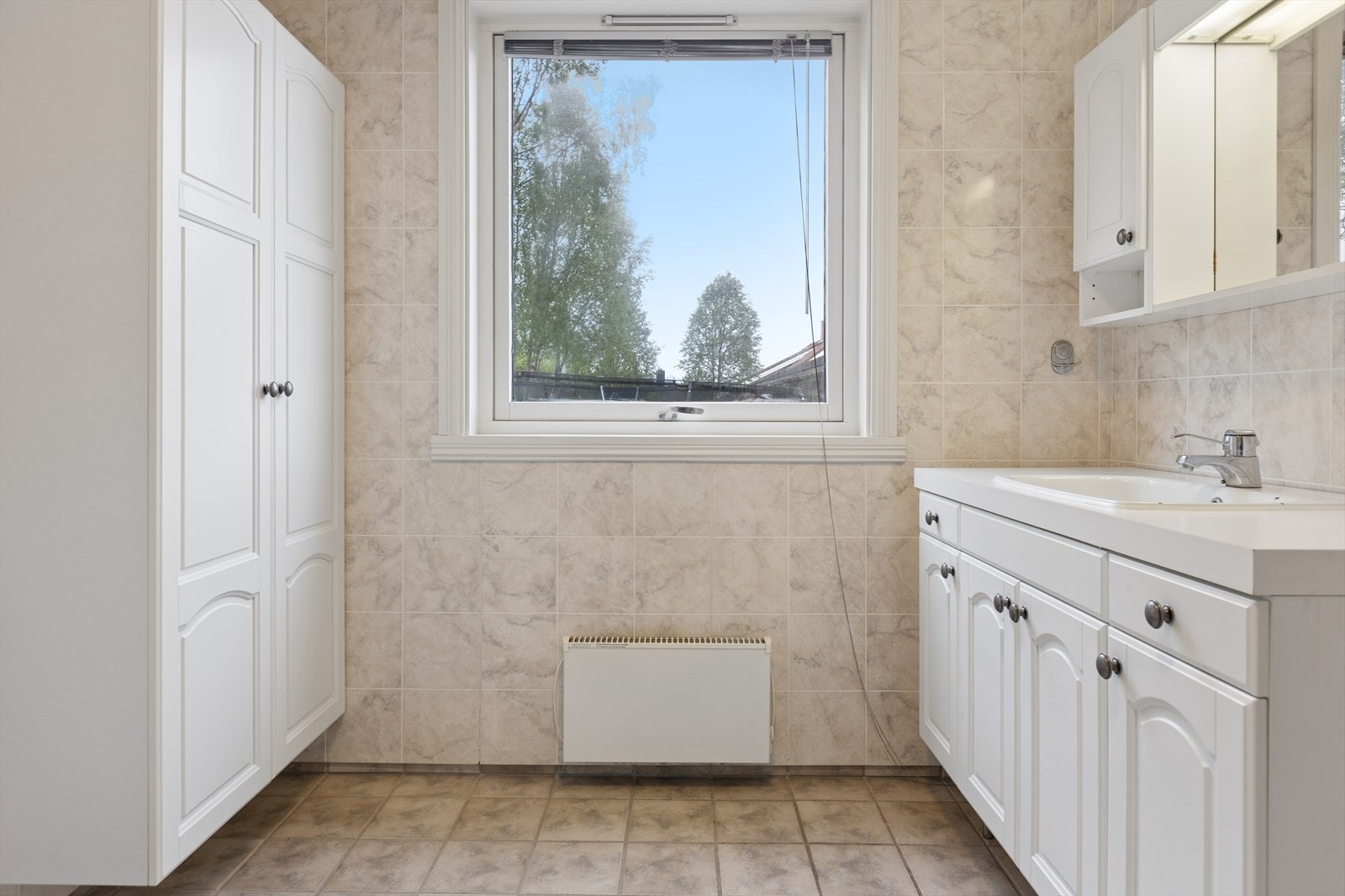 Godt med skapplass på badet. Rommet har naturlig ventilasjon via takventil. Galleribilde