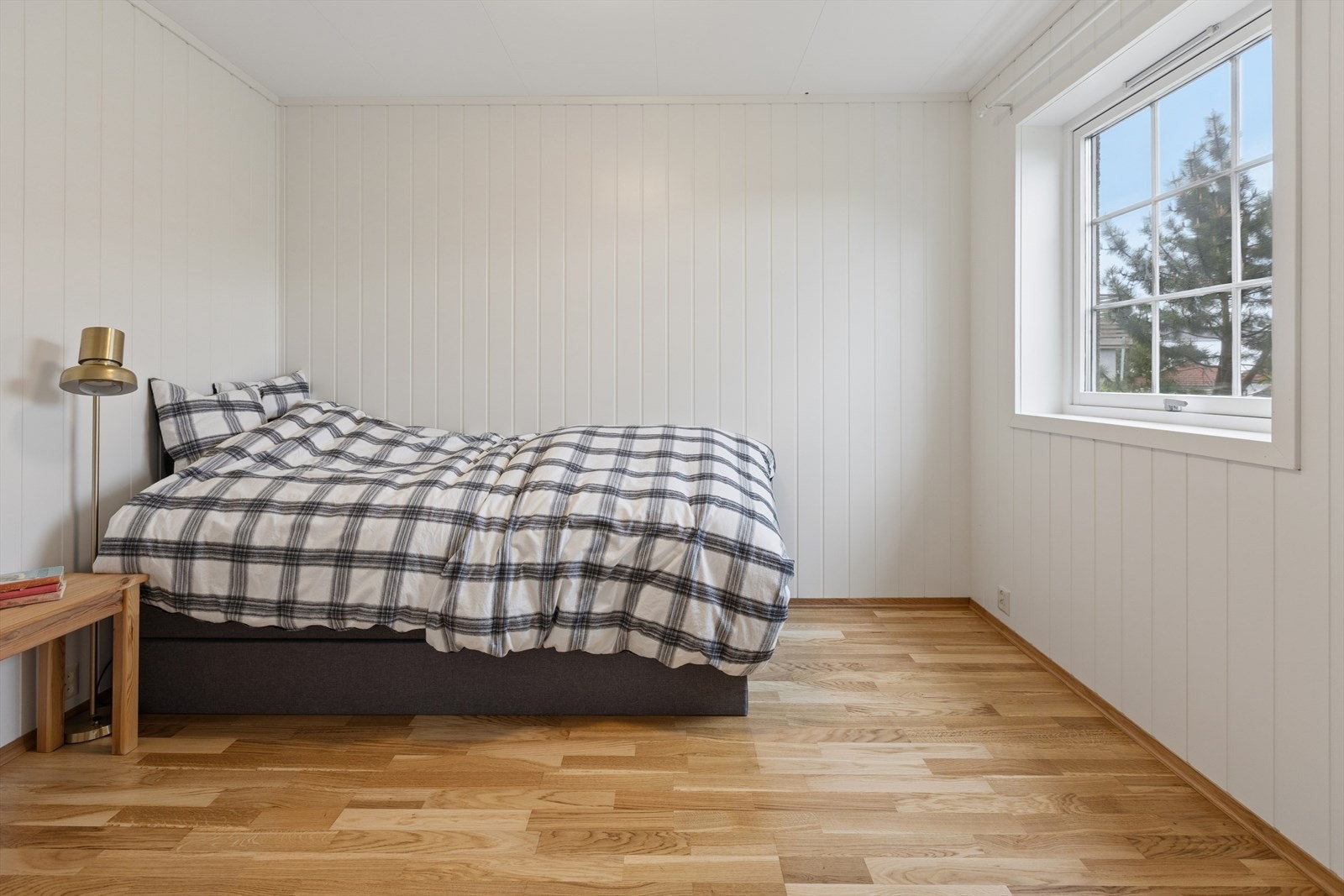 Romslig innredet rom i underetasjen med parkett på gulvet og panel på veggene. Galleribilde