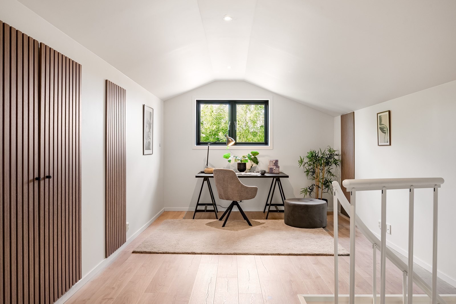 Lys og flott loftstue med pent enstavs gulv, glatte lysmalte overflater, skjult elektrisk anlegg og downlights i himlingen. Skapdører og enkelte vegger er dekorert med stilig trespiler som gir et tidsriktig og moderne uttrykk. Galleribilde