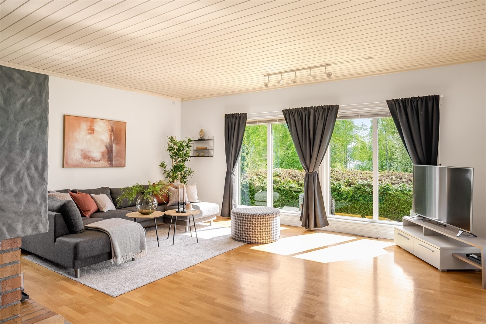 Stor, lys og fin stue med parkett på gulv og lysmalte overflater. Galleribilde