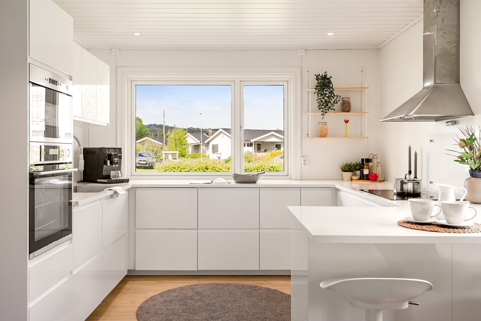Stilren og moderne kjøkkeninnredning fra Ikea som var ny i 2023. Innredningen har hvite glatte fronter og laminert benkeplate med planlimt oppvaskkum. Galleribilde