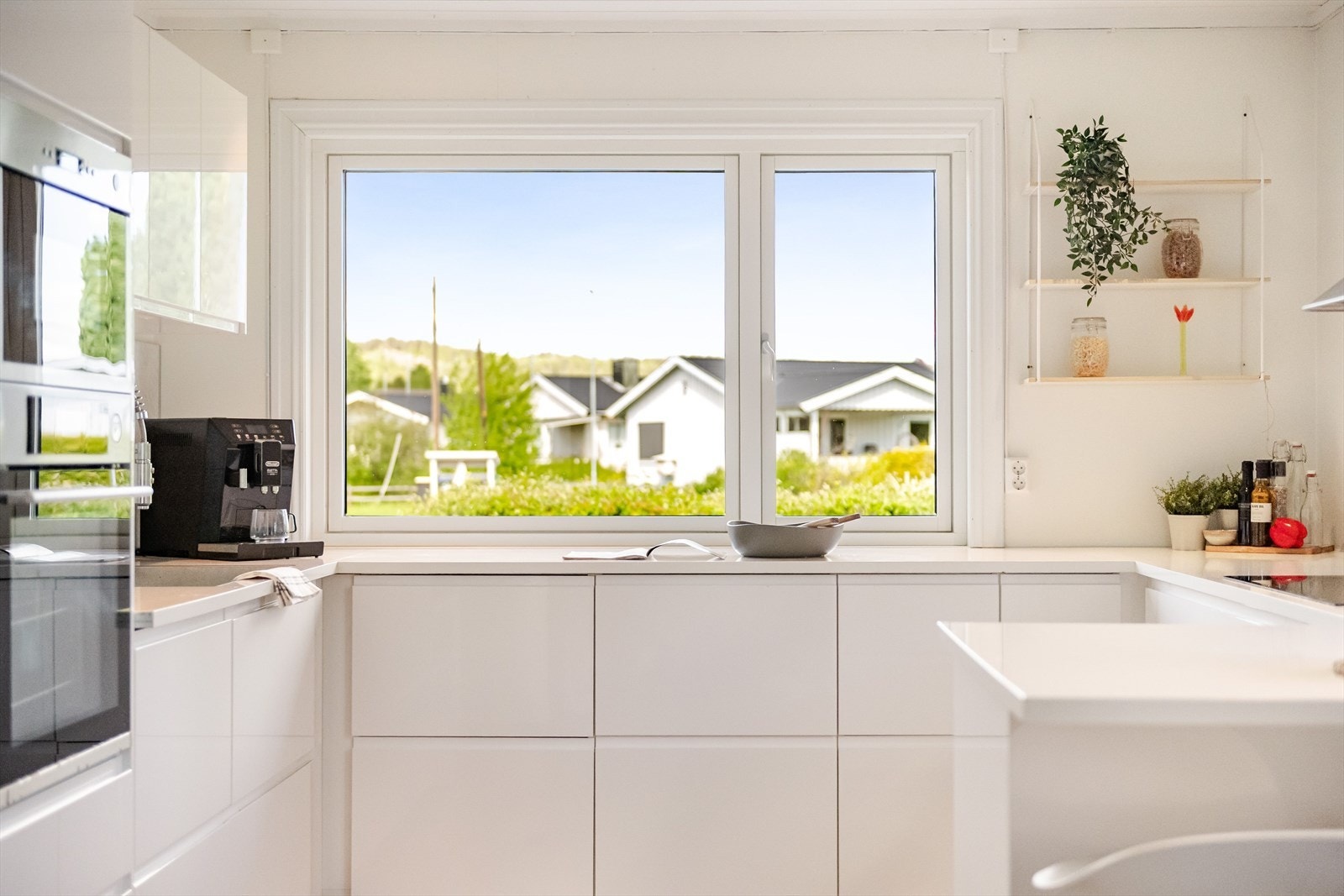 Over kjøkkenbenken er det store vindusflater som slipper inn naturlig arbeidslys. I tillegg er det god belysning med downlights i himlingen. Galleribilde