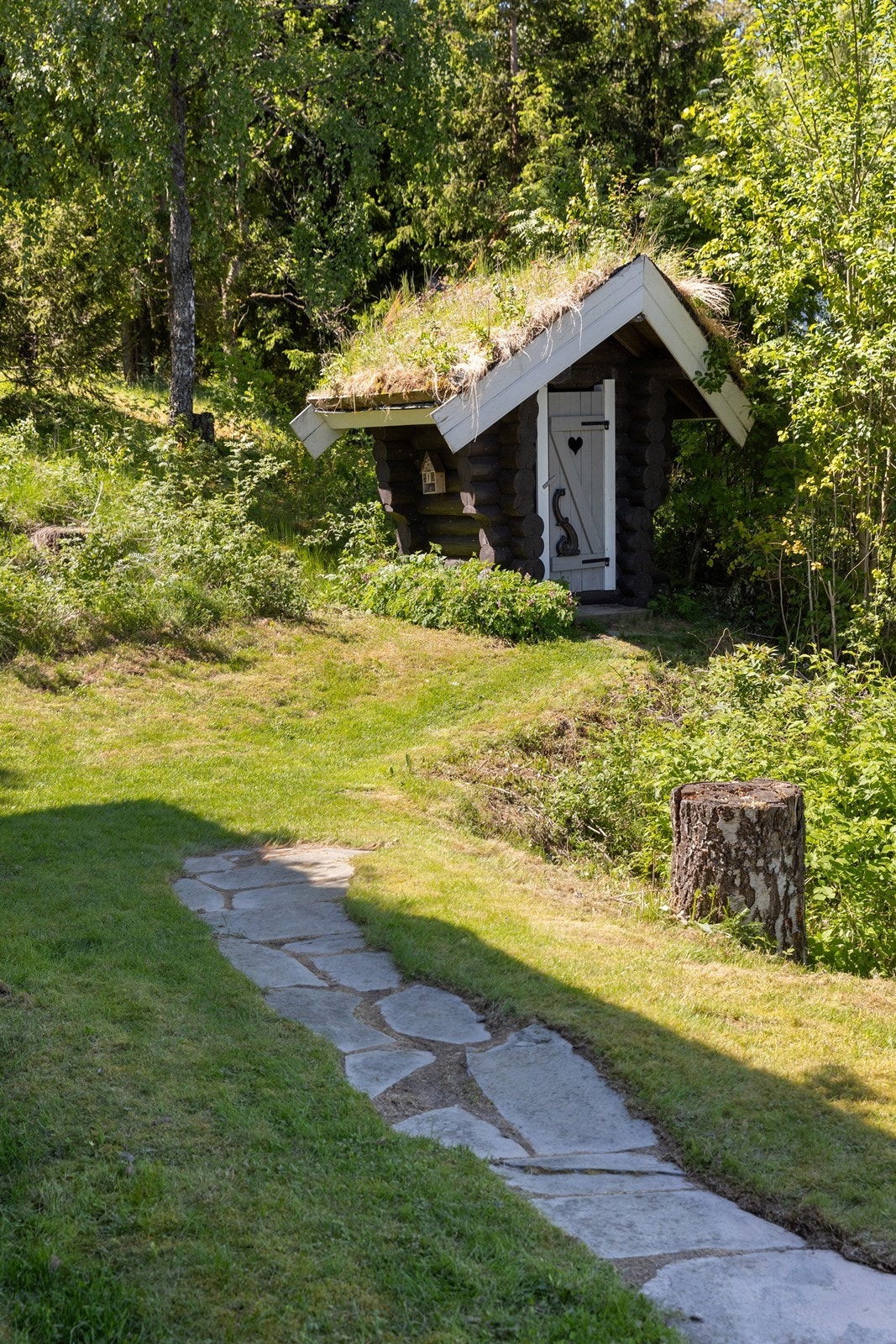 Utedoen er oppført med vegger i laftet tømmer og tak tekket med torv. Galleribilde
