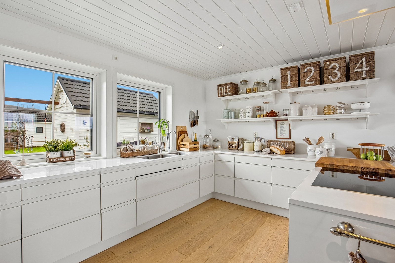Kjøkken er utført med hvite høyglans fronter og Silestone benkeplate Galleribilde