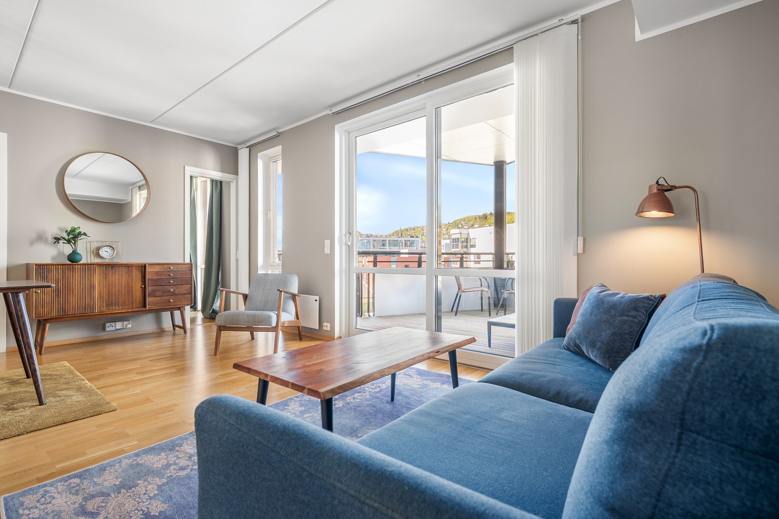 Vinduer fra gulv til tak sørger for masse lys inn og en stue med luftig atmosfære Galleribilde