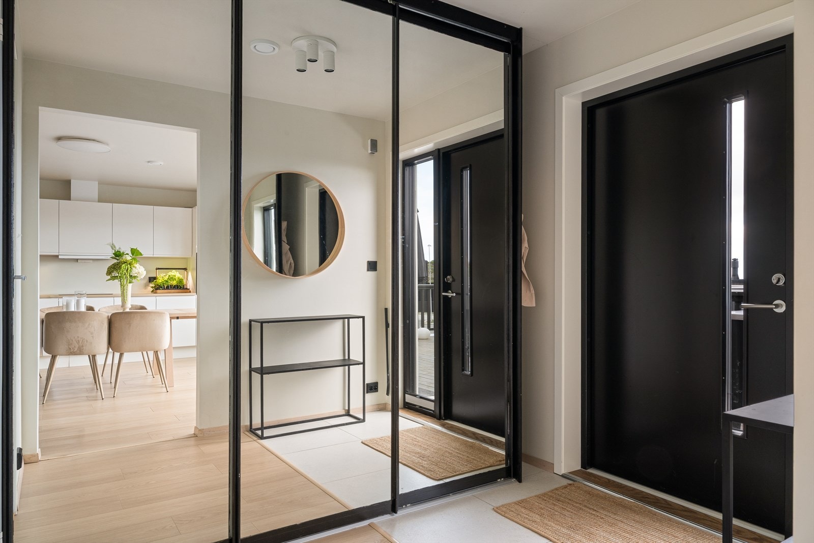 Man ønskes velkommen inn i en lys og romslig entré som er praktisk innredet med delvis flislagt gulv og stor skyvedørsgarderobe som gir rikelig med lagringsplass til familiens yttertøy og sko. Galleribilde
