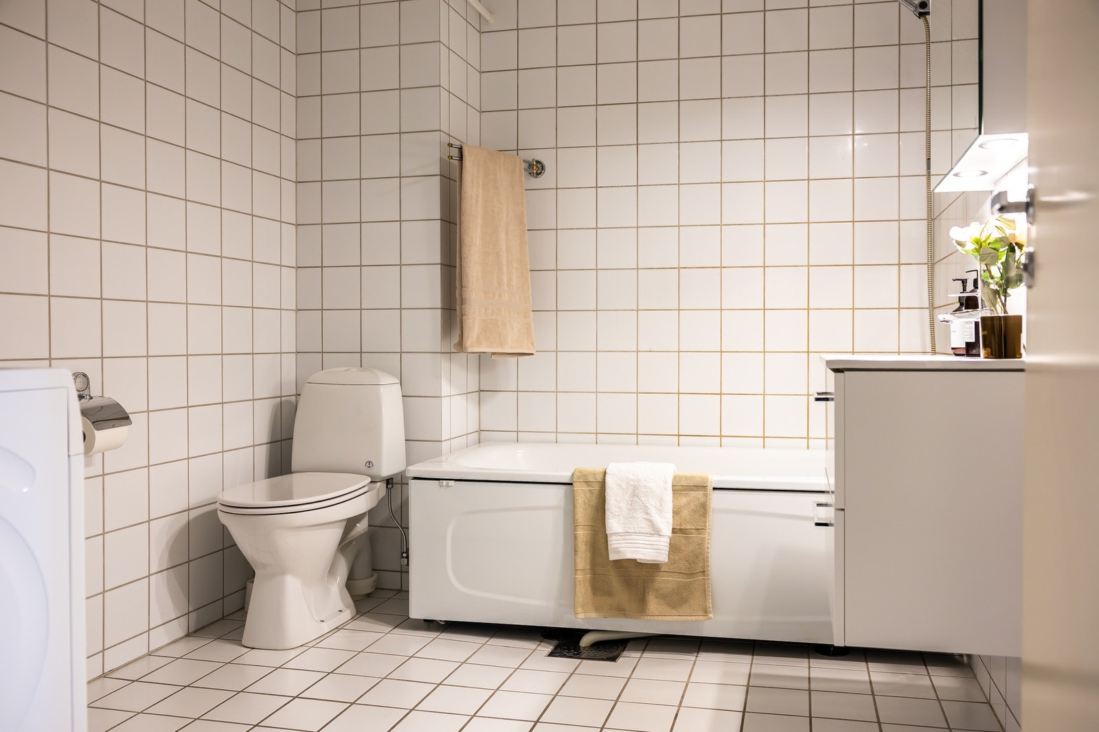 Badekar med dusjbatteri tilkoblet veggmontert hånddusj. Vaskemaskin fra 2026 kan medfølge. Avtrekksventil er plassert på vegg. Galleribilde