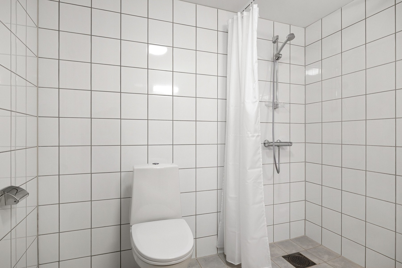 Romslig bad med fliser på vegger og gulv, samt gulvvarme. Galleribilde