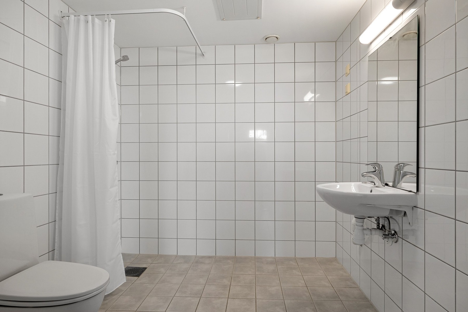 Romslig bad med fliser på vegger og gulv, samt gulvvarme. Galleribilde
