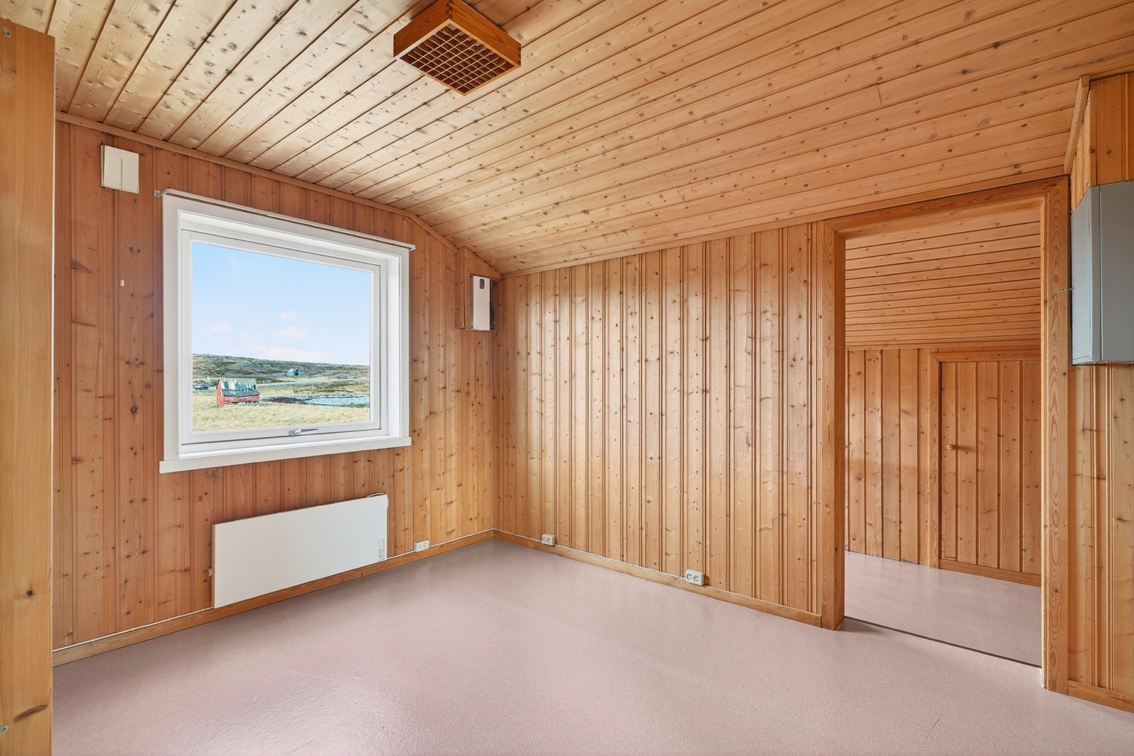 Et av rommene på loftet med vegger og himling kledd i trepanel. Galleribilde