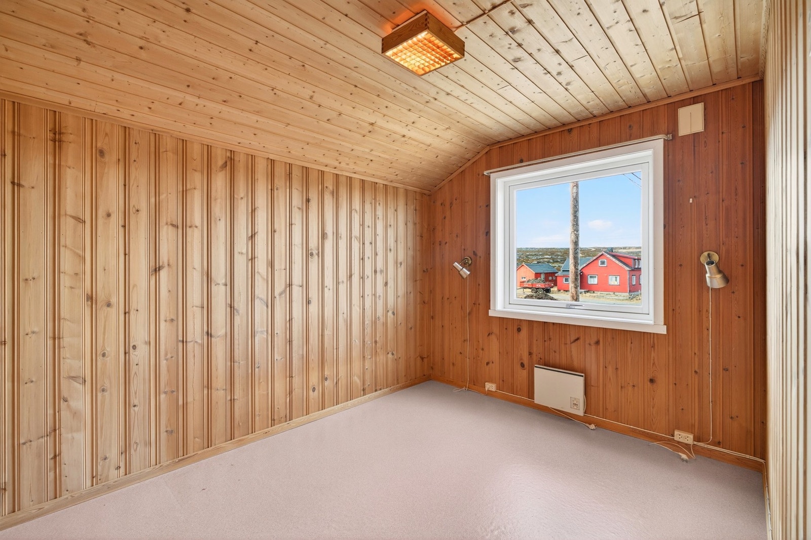Loftet har en kombinasjon av tapetserte vegger og trepanel. Galleribilde