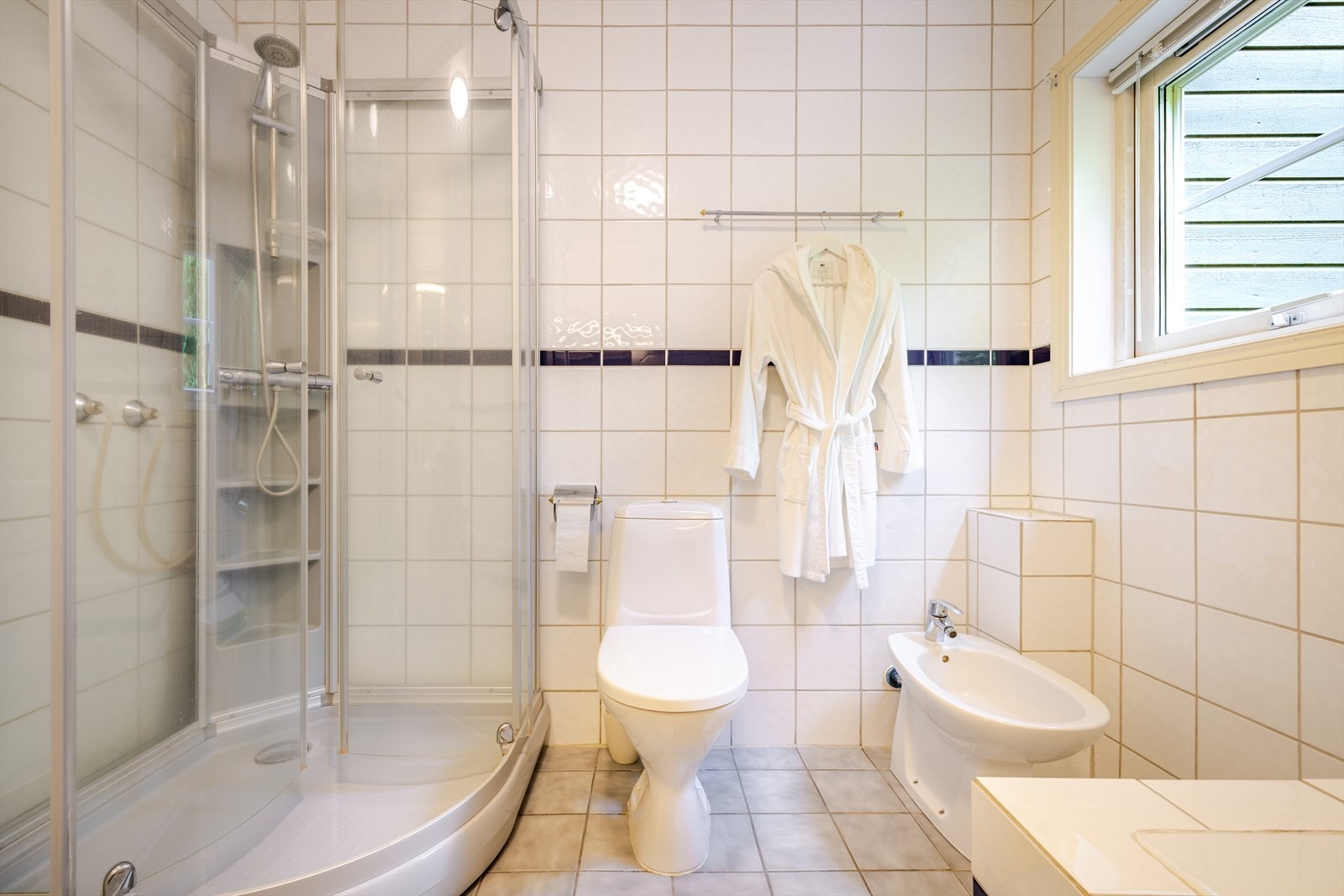 Rommet har dusjkabinett, wc, bidé og innmurt badekar Galleribilde