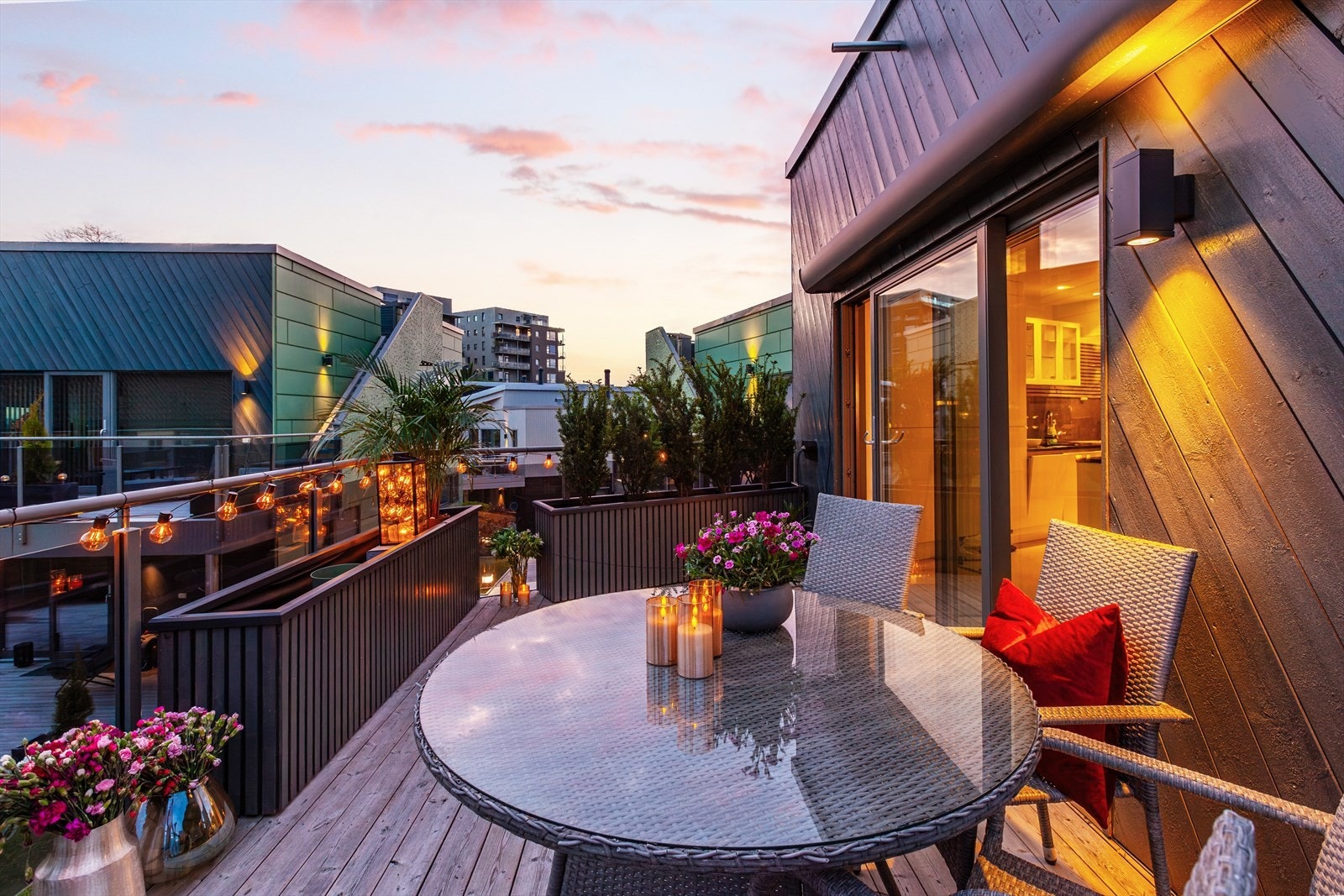 Kveldsstemning fra verandaen. Skjerming mot sameiet er løst med lange blomsterkasser som gir mulighet for å skjerme i den grad man ønsker med varierende høyde på beplantning. Om ønskelig følger disse boligen. Galleribilde