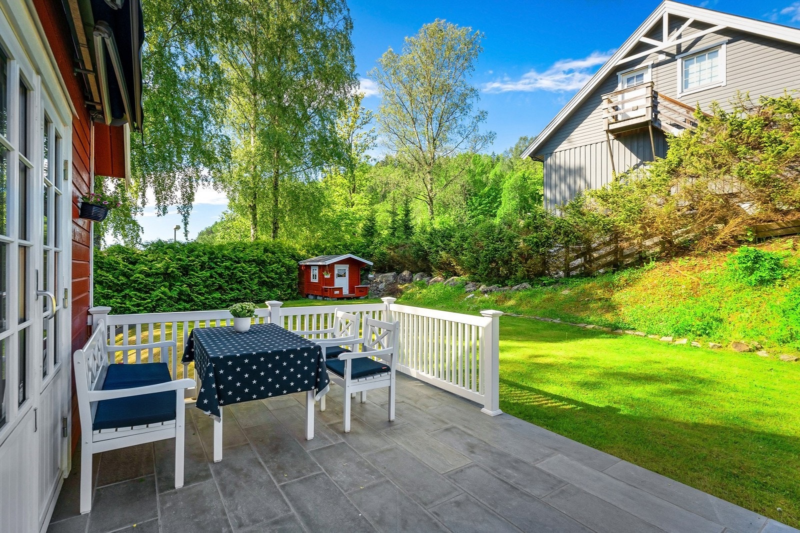 Boligens terrasse er vestvendt med videre tilgang til hagen Galleribilde