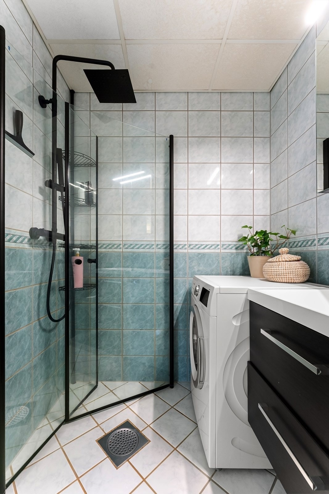 Badet har et praktisk dusjhjørne med innfellbare glassdører og opplegg for vaskemaskin. Galleribilde