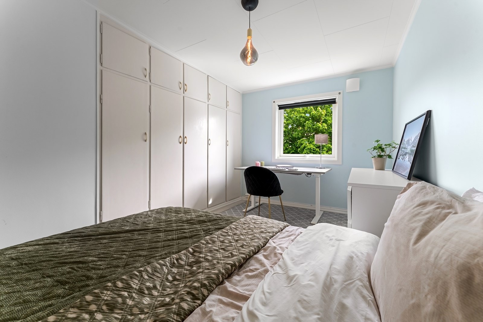 En hel vegg med plassbygde garderobeskap gir rikelig med oppbevaringsplass. Galleribilde