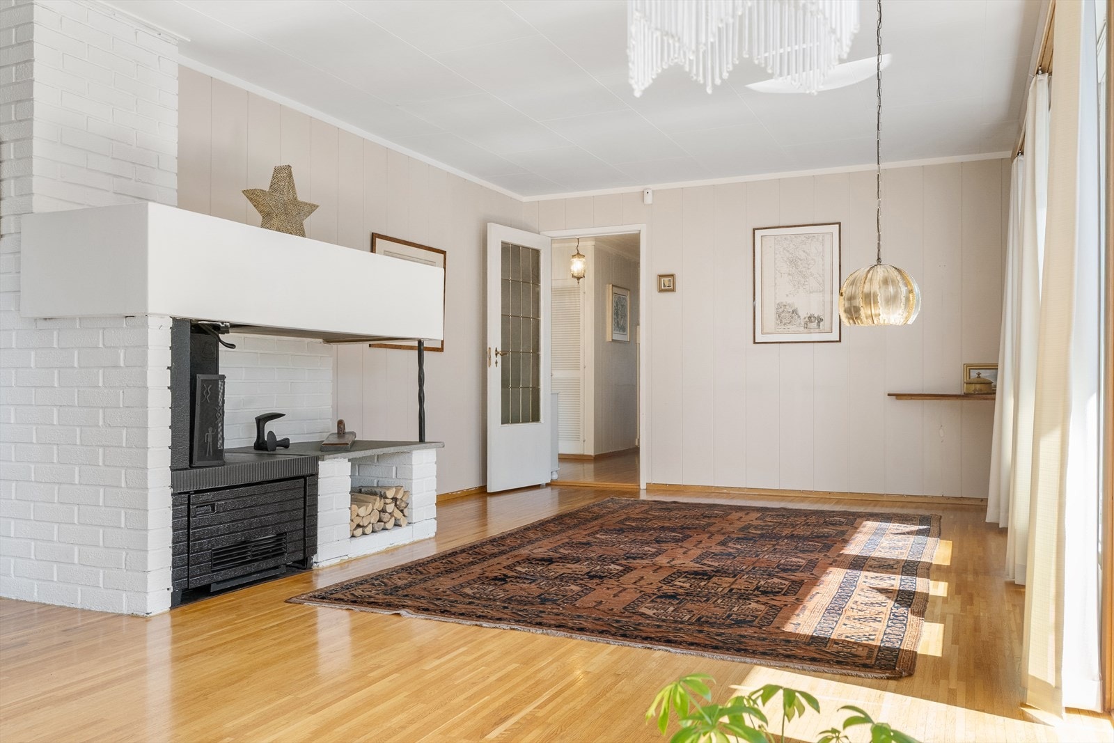 En murt peis er plassert sentralt i stuen. Galleribilde