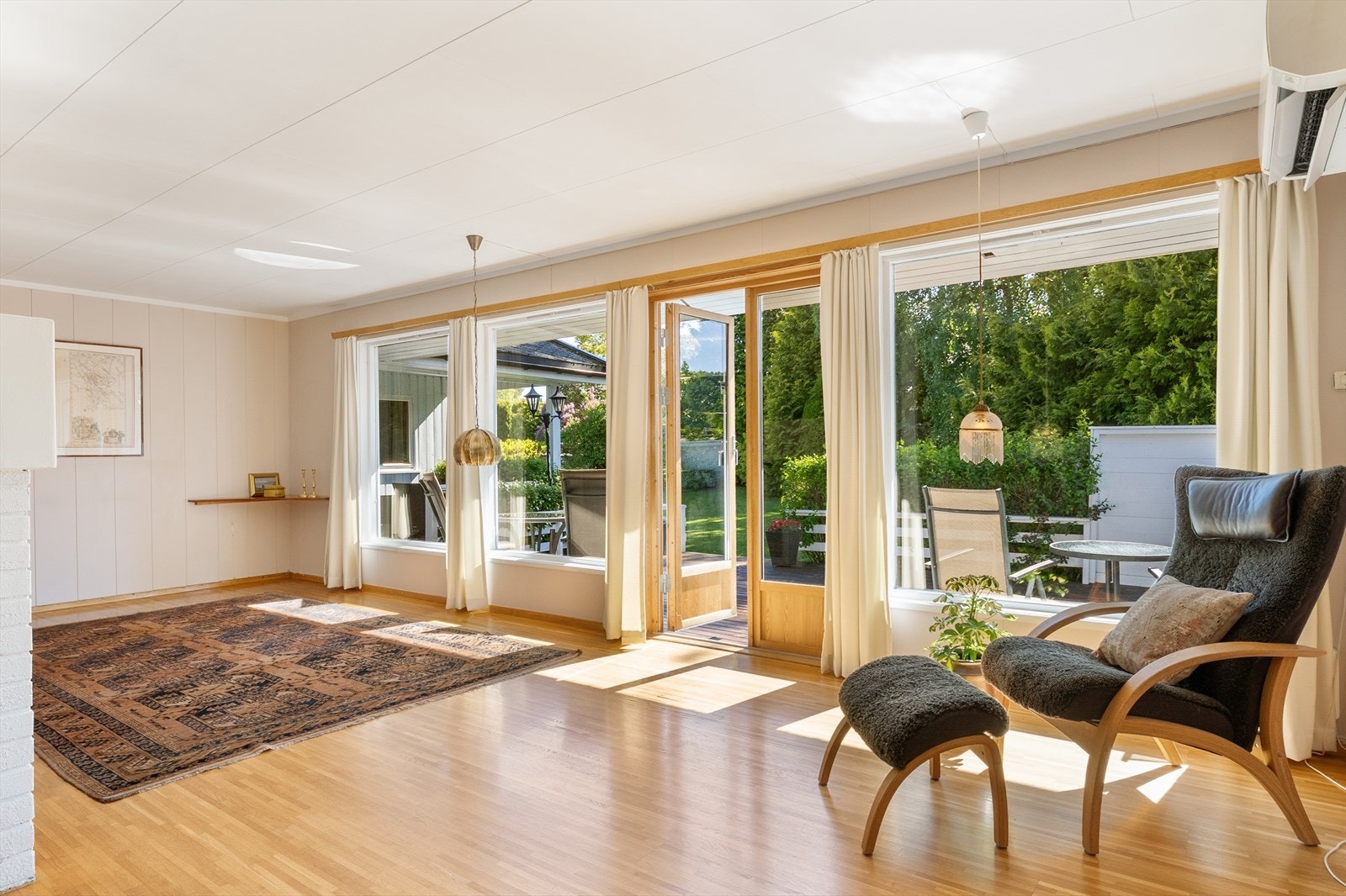 Stuen har store vindusflater som slipper inn rikelig med naturlig lys og gir rommet en lys og luftig følelse. Galleribilde