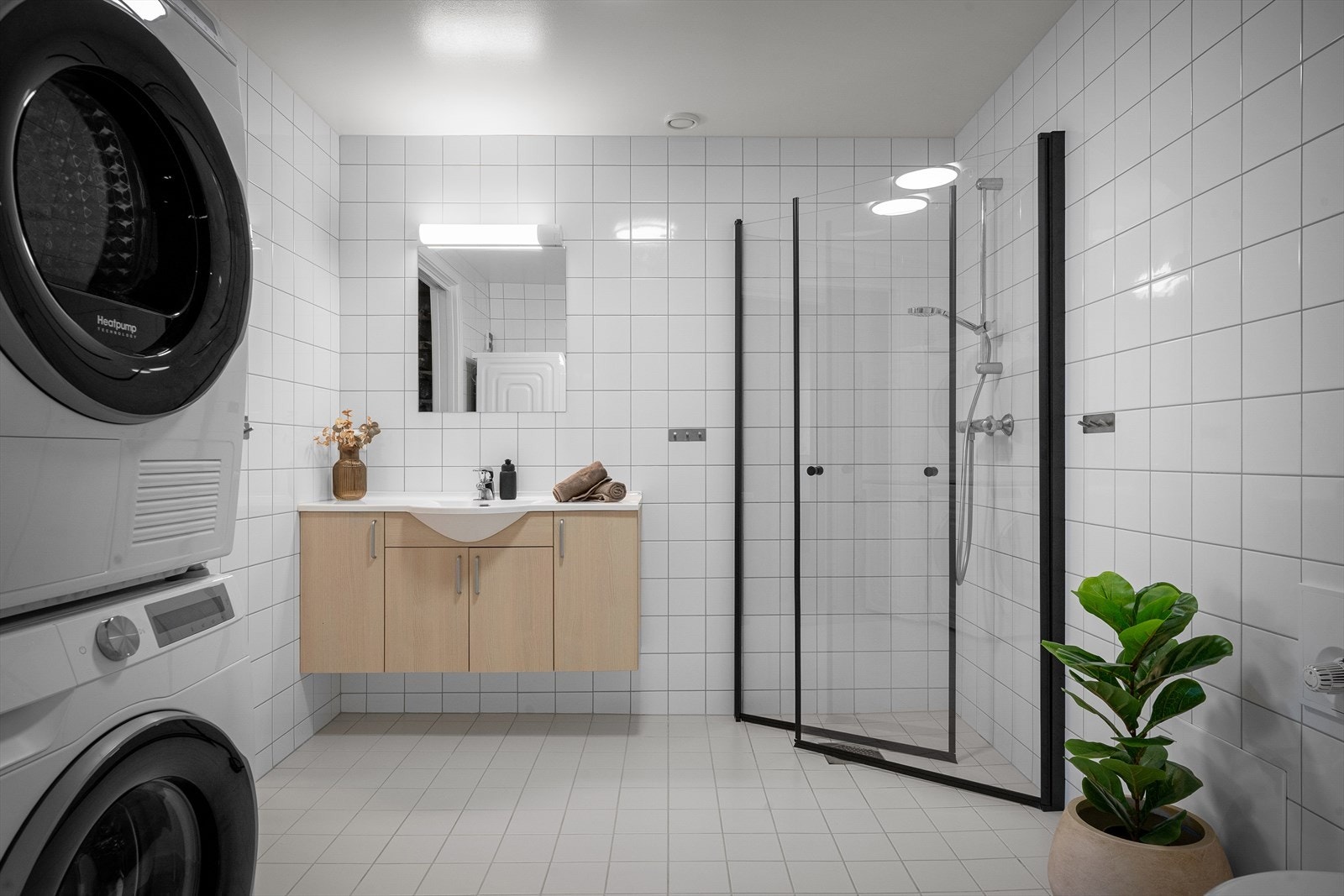 Romslig, flislagt bad med vannbåren gulvvarme og opplegg for vaskemaskin og tørketrommel Galleribilde