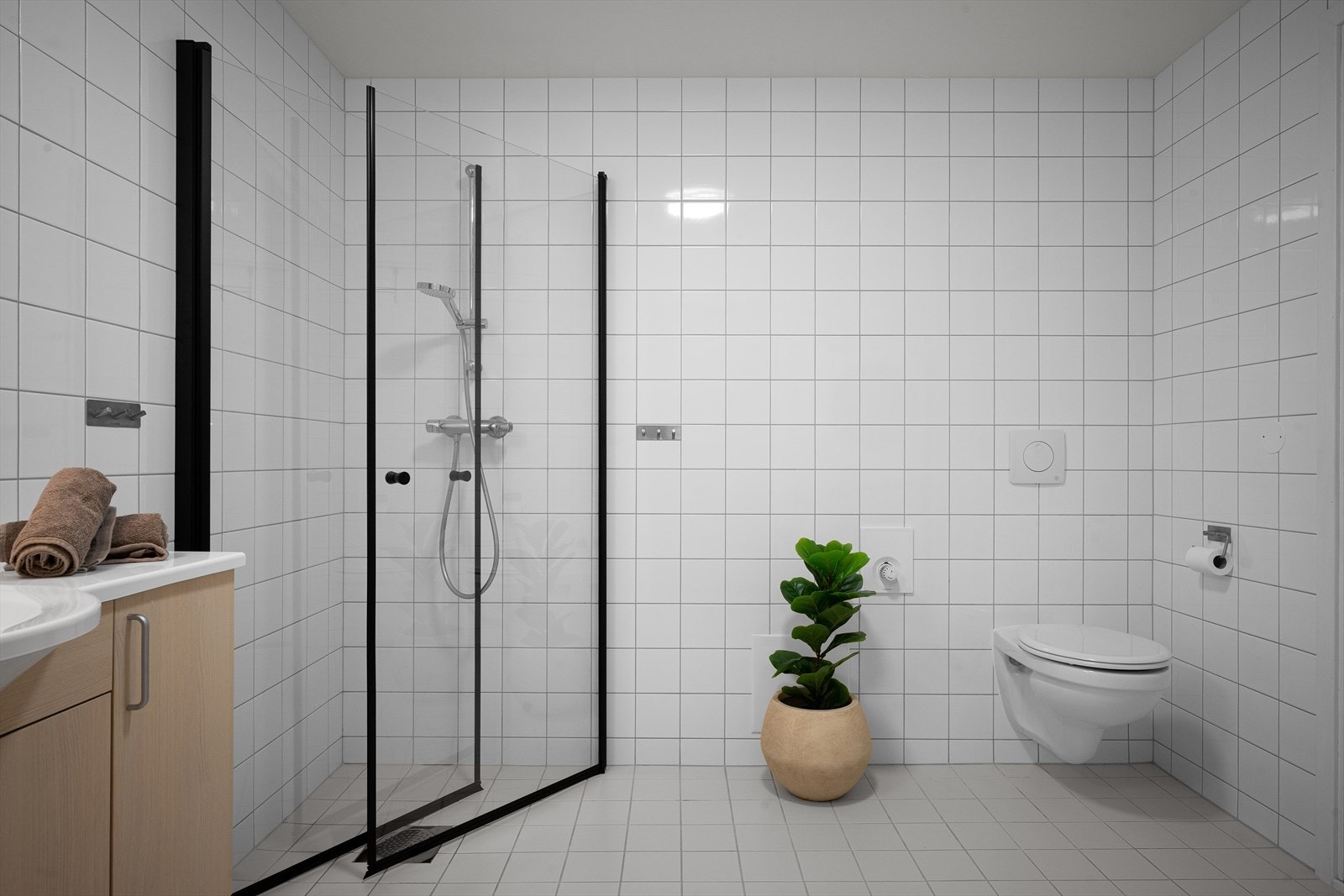 Badet er utstyrt med vegghengt toalett og dusjhjørne med nye glassdører fra 2026. Galleribilde