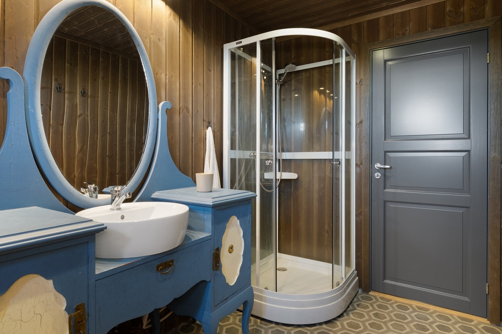 Badet er innredet med servantskap med servant, gulvmontert toalett (Separett villa tørrtoalett) og dusjkabinett. Galleribilde