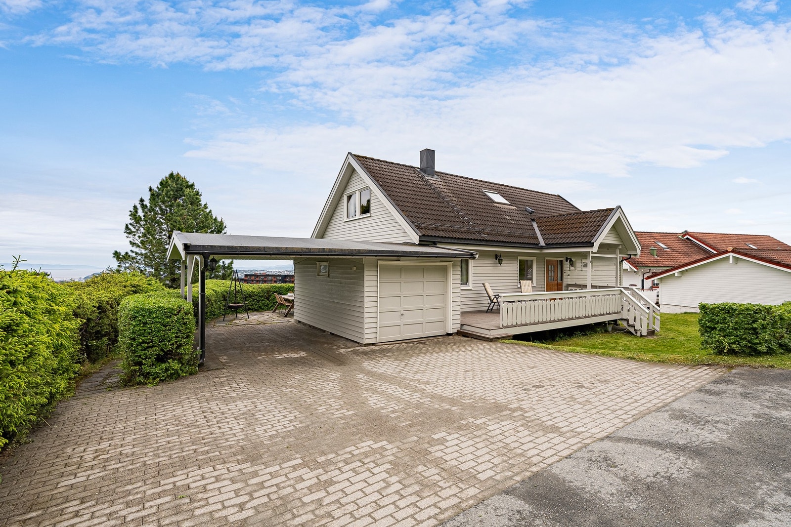 Steinbelagt innkjøringsparti, her har man både carport og garasje. Galleribilde