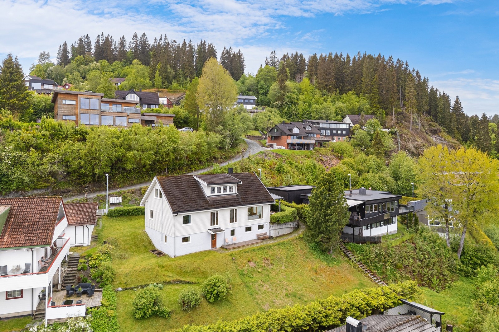 Eiendommen ligger i enden av blindvei og på et høydedrag med garasje + carport og oppstillingsplass. Hage på baksiden og framsiden av huset. Galleribilde