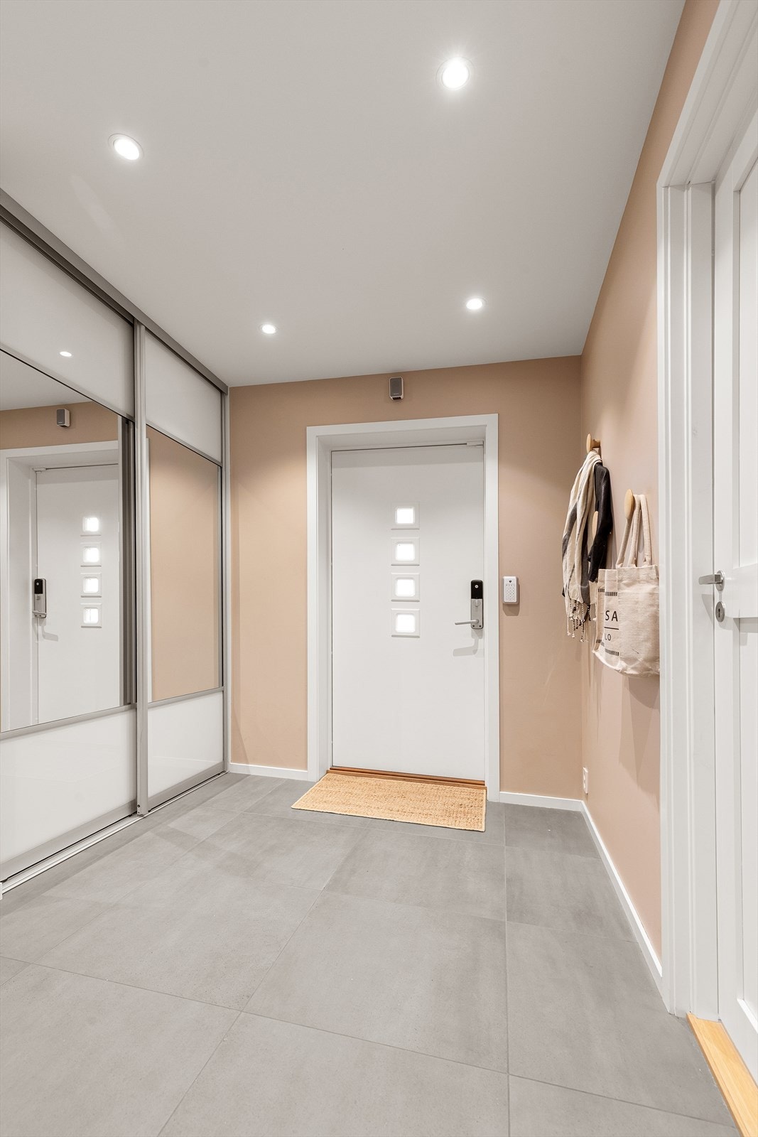 Velkommen inn i en romslig gang med flislagt gulv og varmekabler Galleribilde